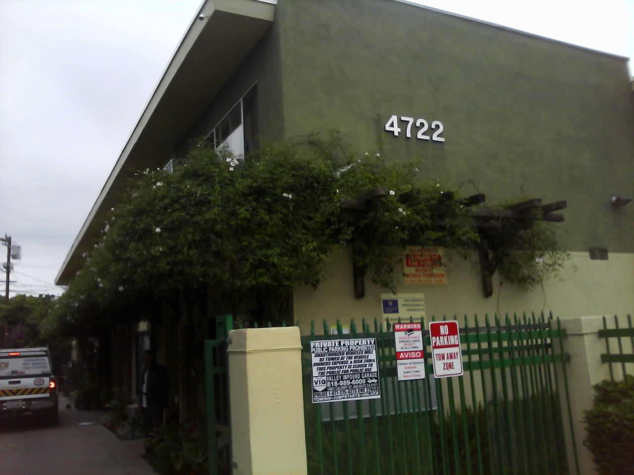 Corner view of 4722 Delano ll apartments showing Green building with ivy filled trellis attached to building