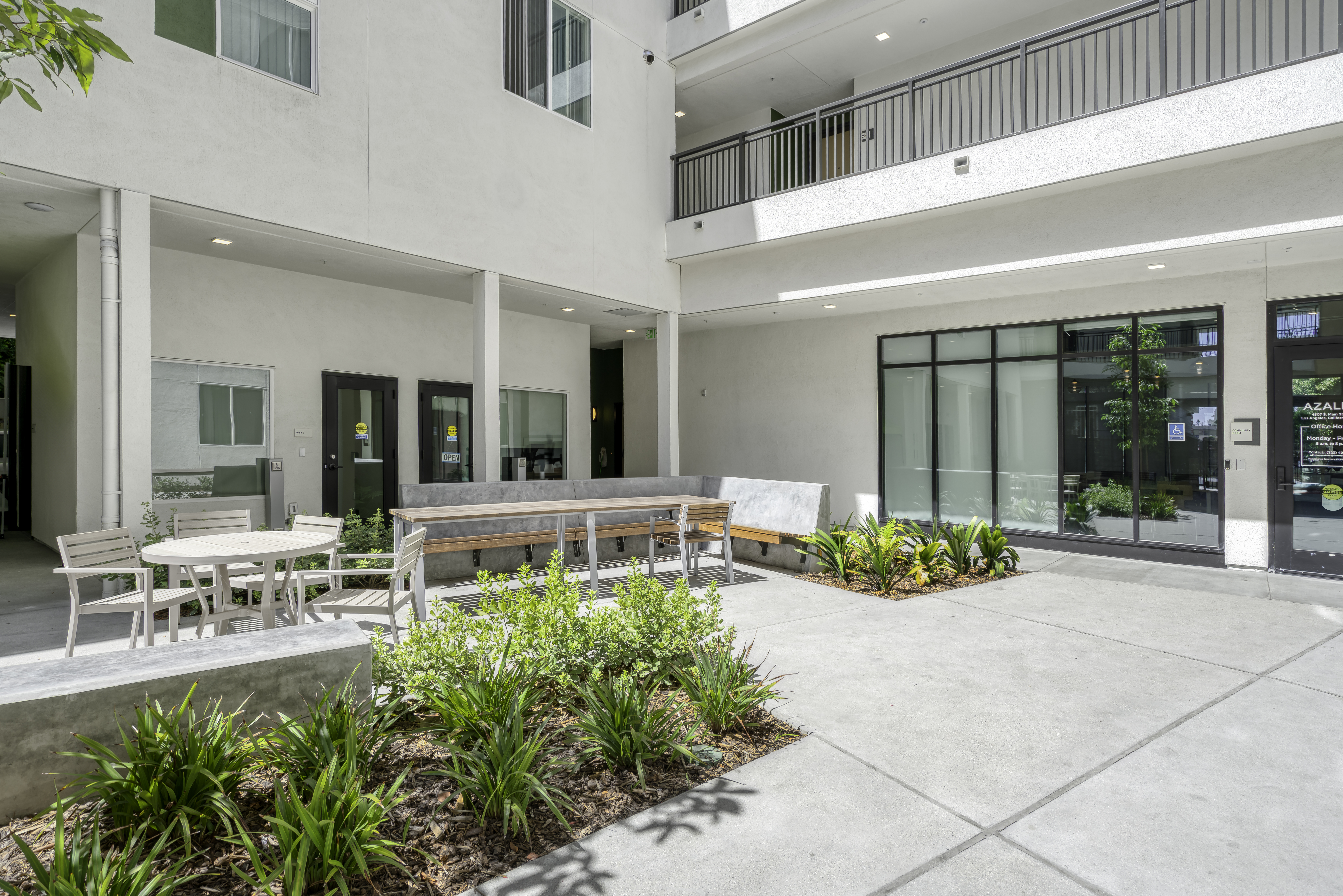 Common Area. The outside courtyard within the building showing table, chairs, bench, and table seating. 