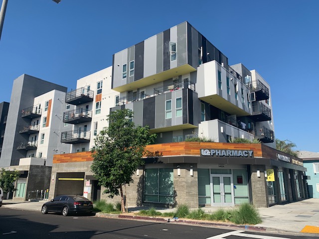 Street view of 5400 Hollywood Family Apartments showing a Pharmacy on the corner ground floor of the building
