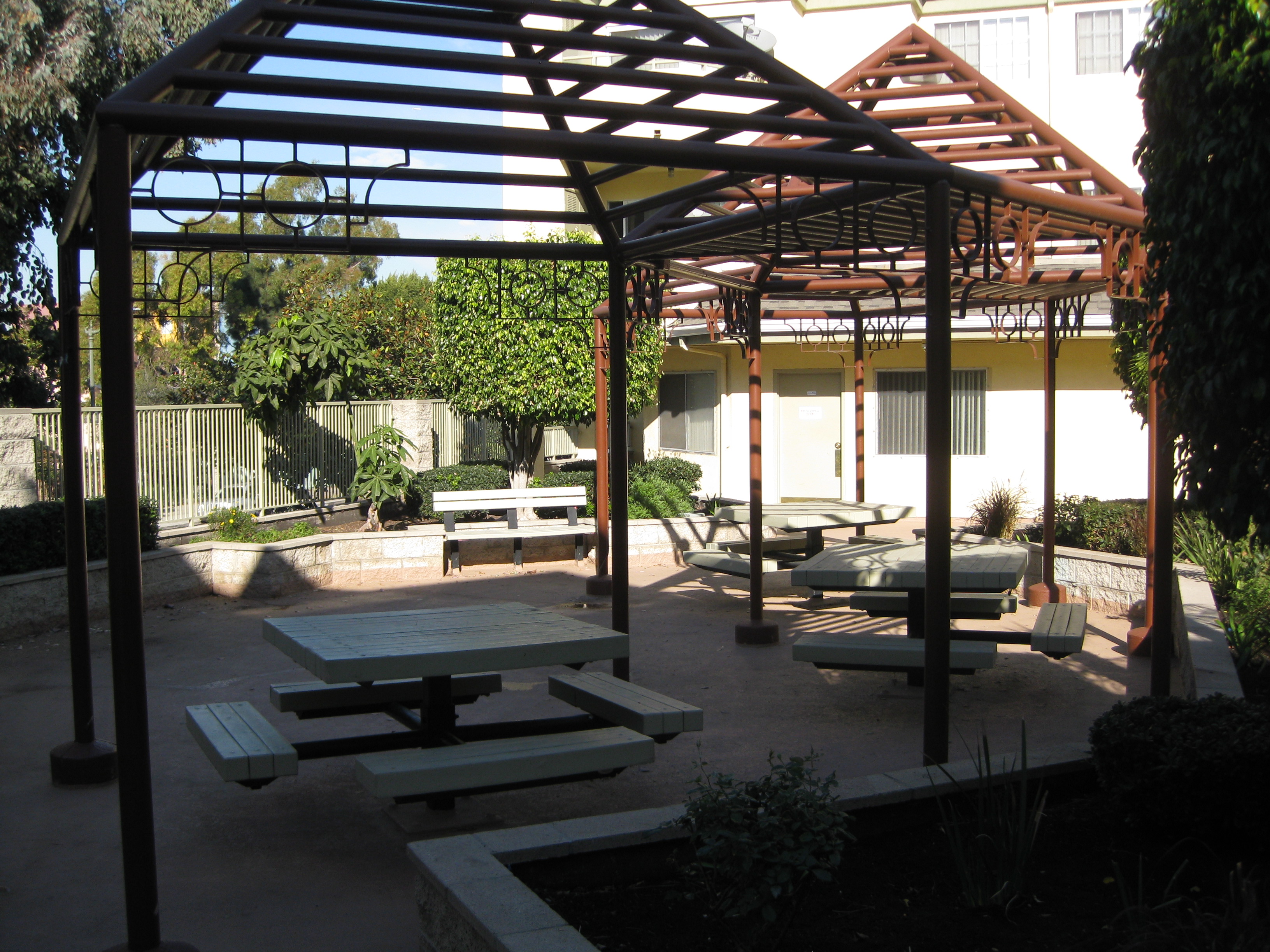 Paradise arms common area. gazebos with table bench seating. raised bed planters circling seating area.