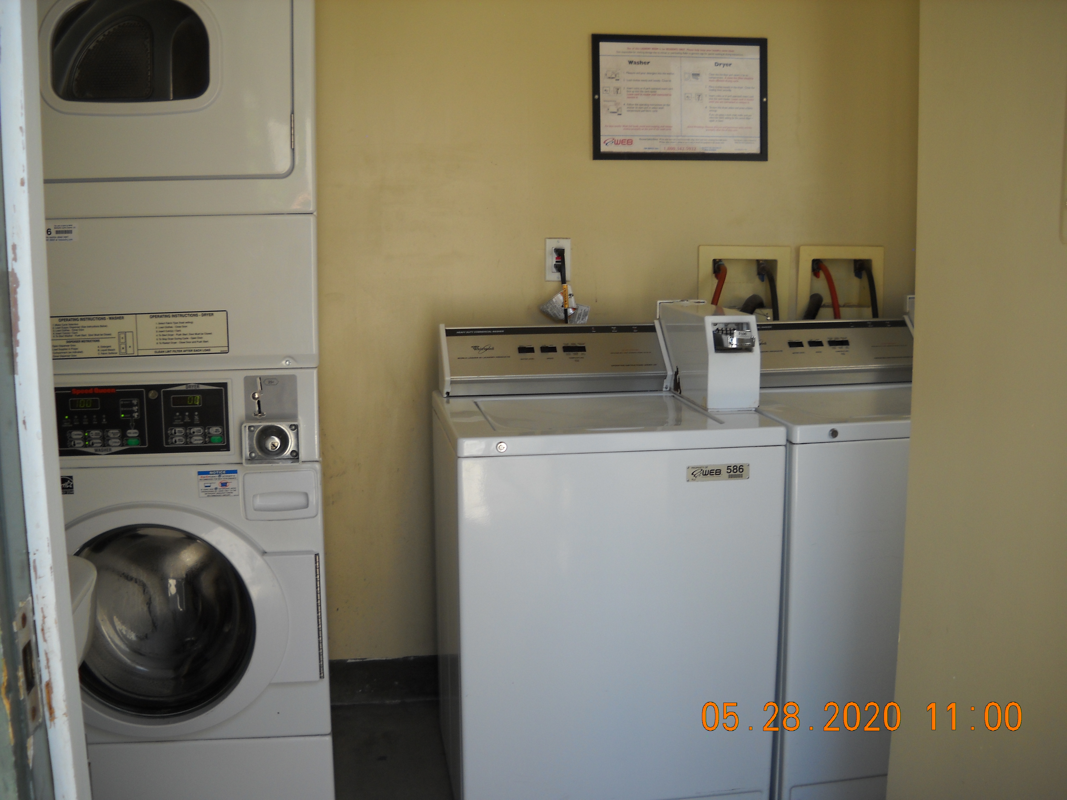 Laundry room with four machines visble, and an instruction sign posted on the wall.