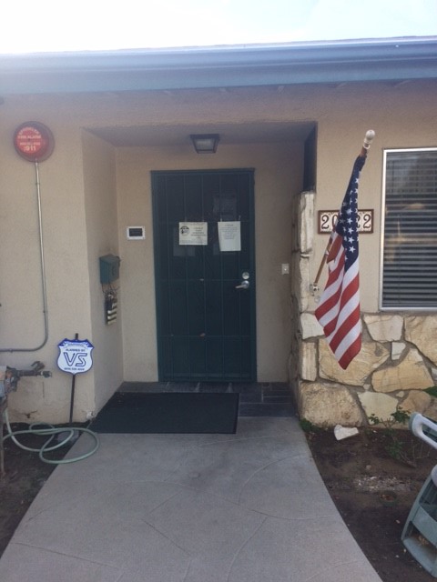View of front entrance including  an American flag to the right of the front door.