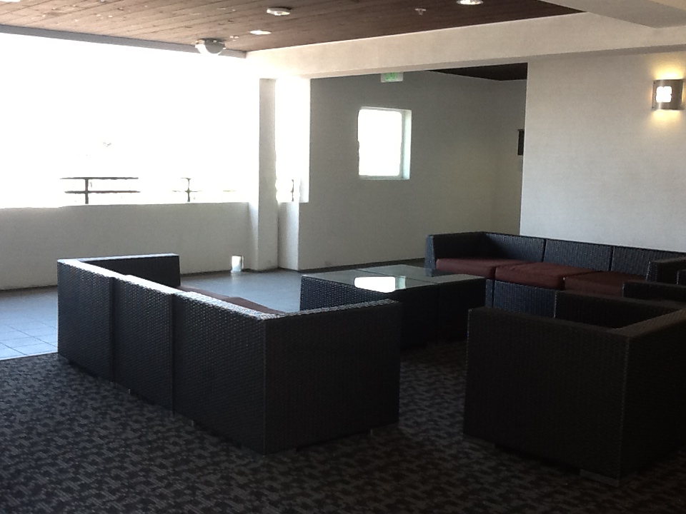 Interior view of a lounge area at Rio Vista Apartments. Two sofas and sofa chair with a coffee table in the middle