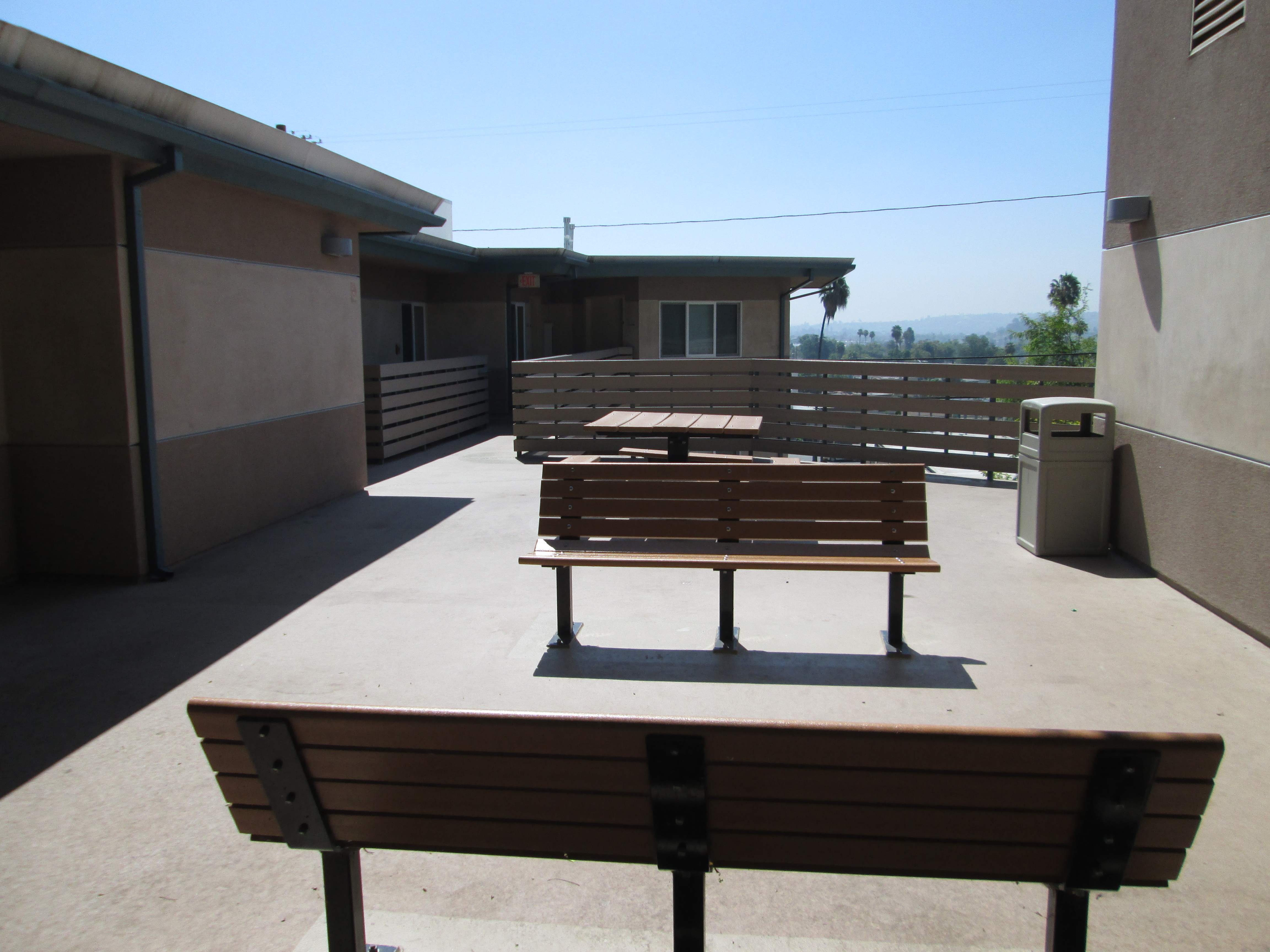Exterior view of a common area at Cuartro Vientos showing benches and a picnic table