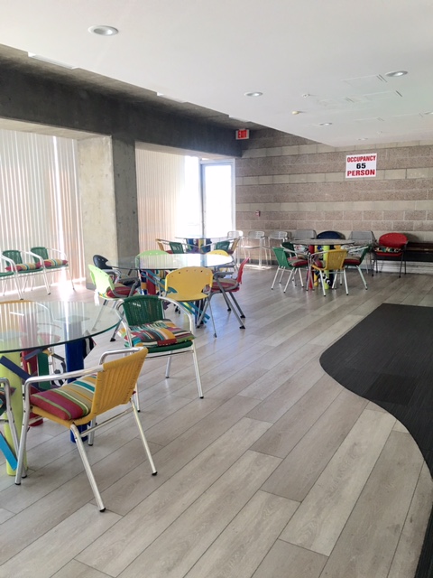 Spacious first floor community room with multiple tables and seating.