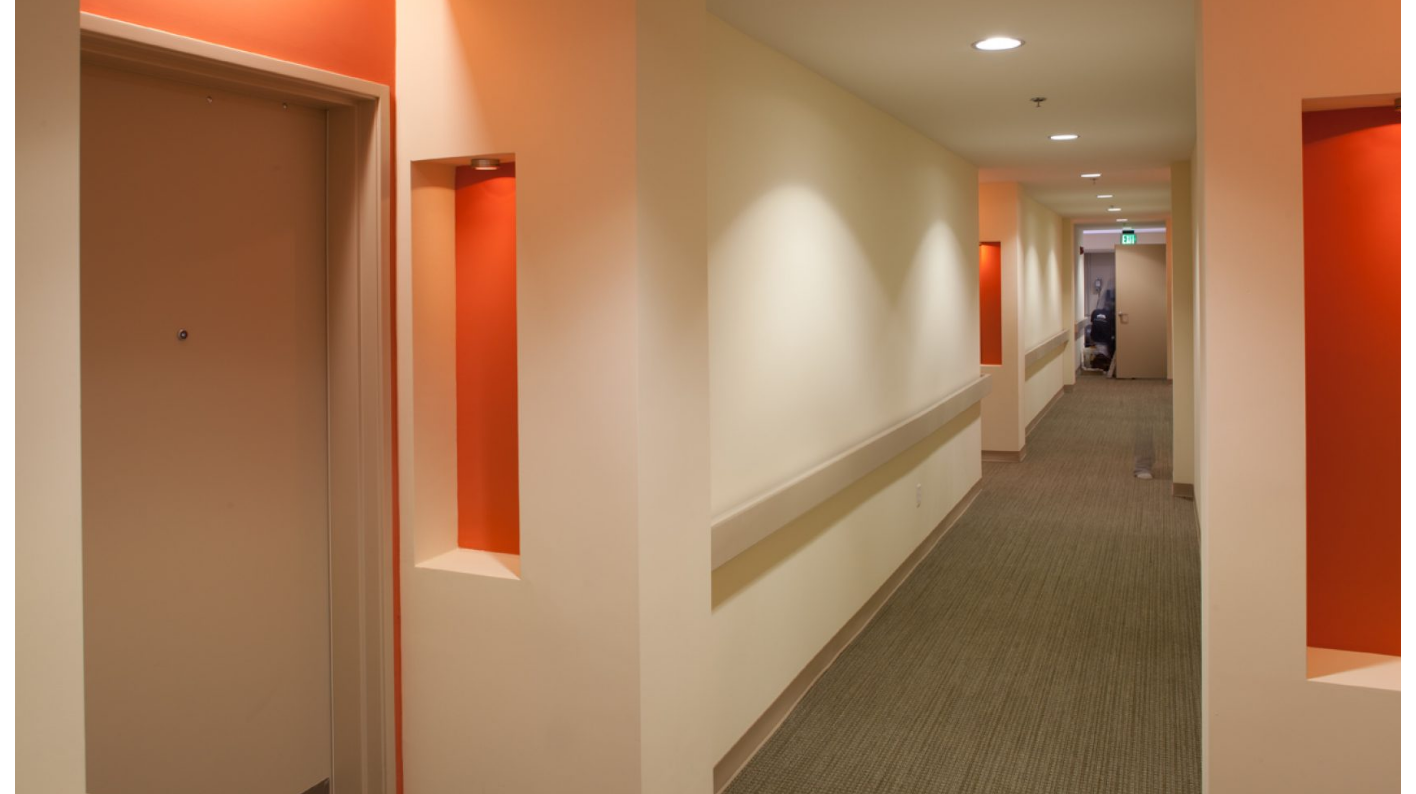 Hallway - textured carpet, wood railings, recessed lights in walls
