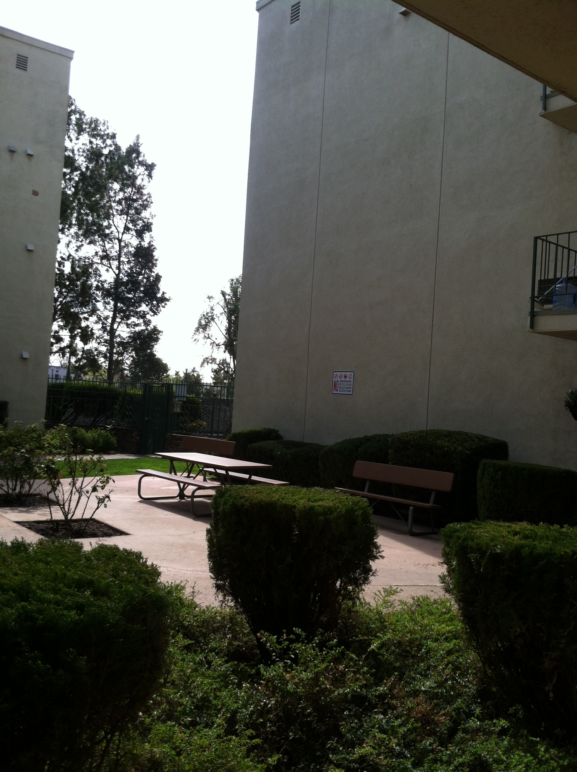 Exterior view of a common area with a picnic table, a bench and landscaping at Ingram Preservation Propeties