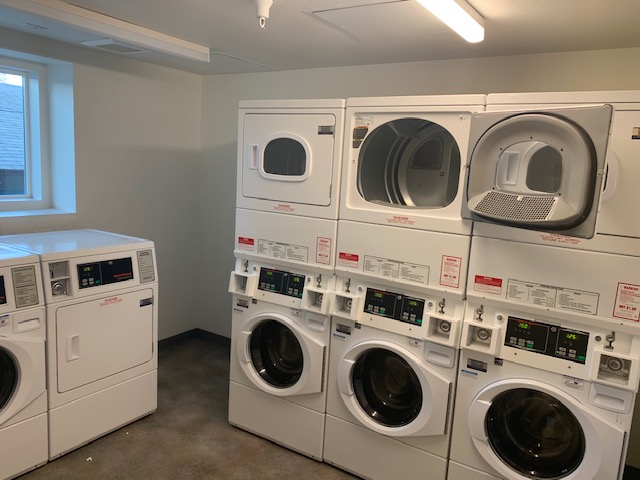 Interior view of a laundry room. Appliances are both double stacked and single lower leveled.