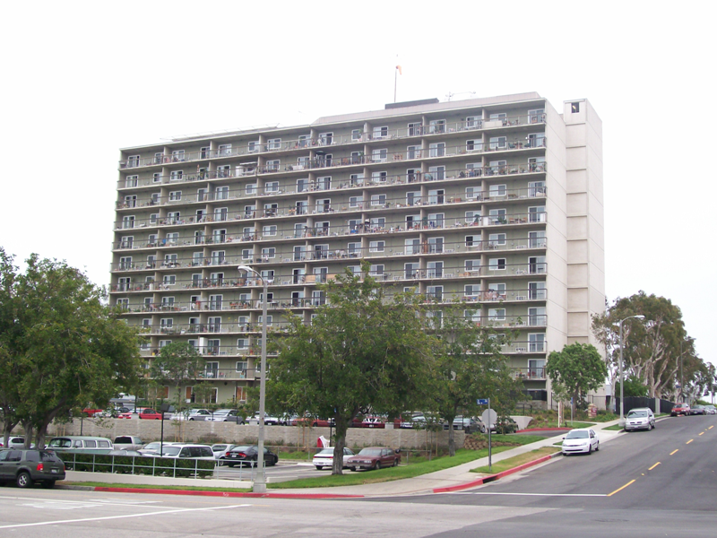 Image of 12 story building with balcony and parking lot