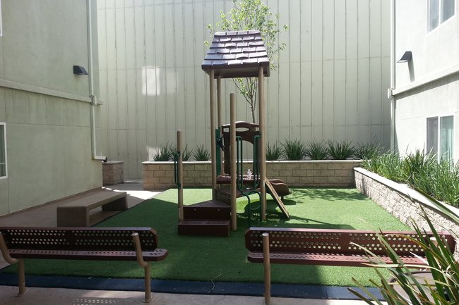 Courtyard - Benches overlooking mini play structure (small deck and slide, astroturf)