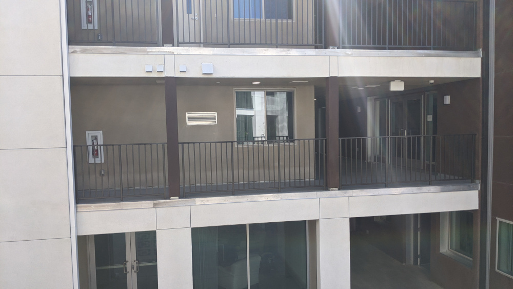 Hallways opening onto courtyard with guardrail