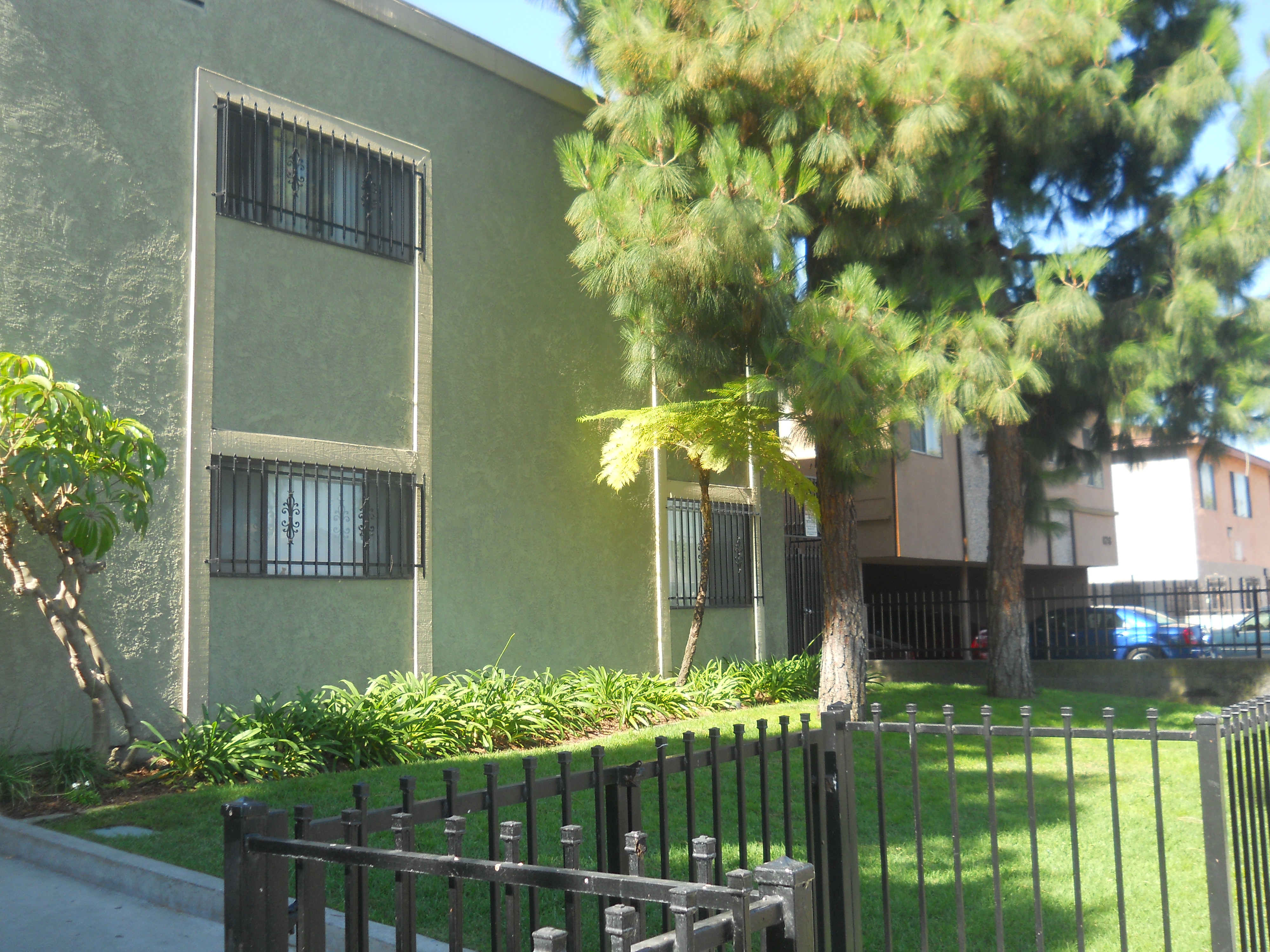 Nyumba Apartments front entrance - two story building sage with yellow trim.