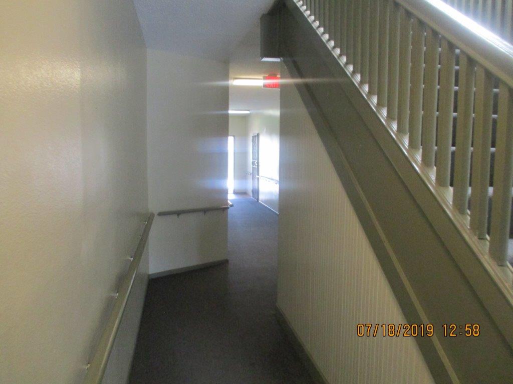 Interior view of hallway with guard rail on the ground floor of property