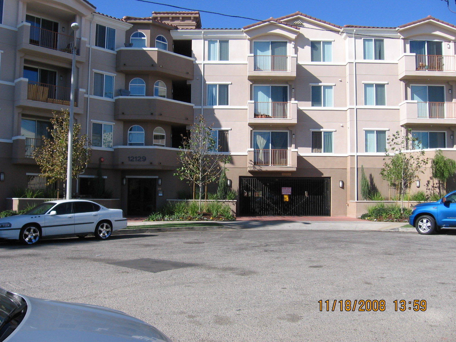 Front view of 4 floor family apartemnt building in culdesac with balconies and garage entrance on first floor
