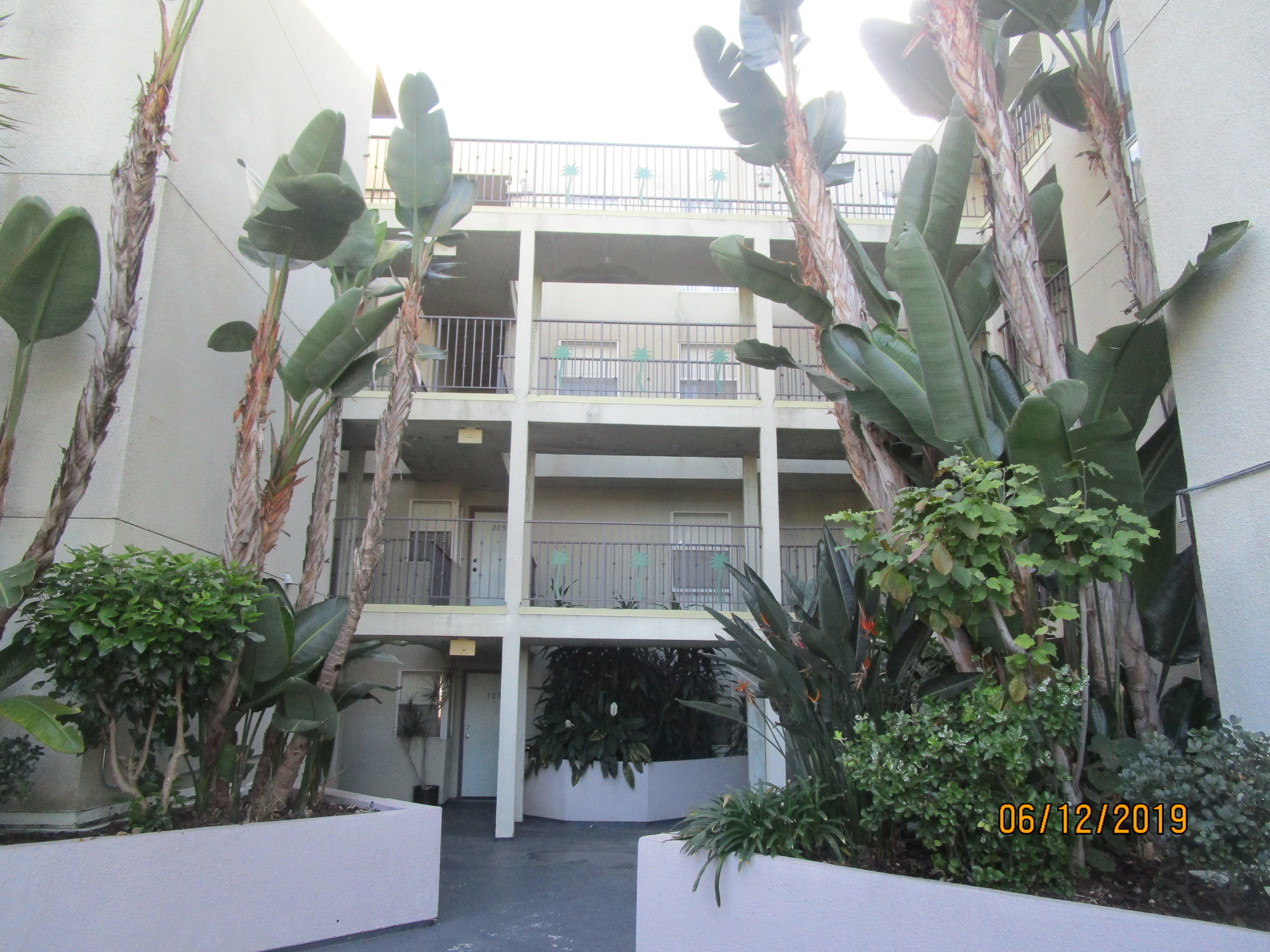 Front view of a patio, concrete floor, built in concrete planters on the left and right side.