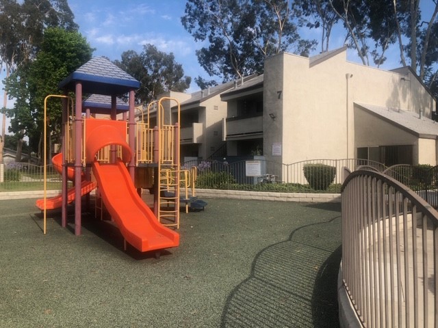 Lankershim arms gated playground area. softpave ground with large jungle gym with slide.