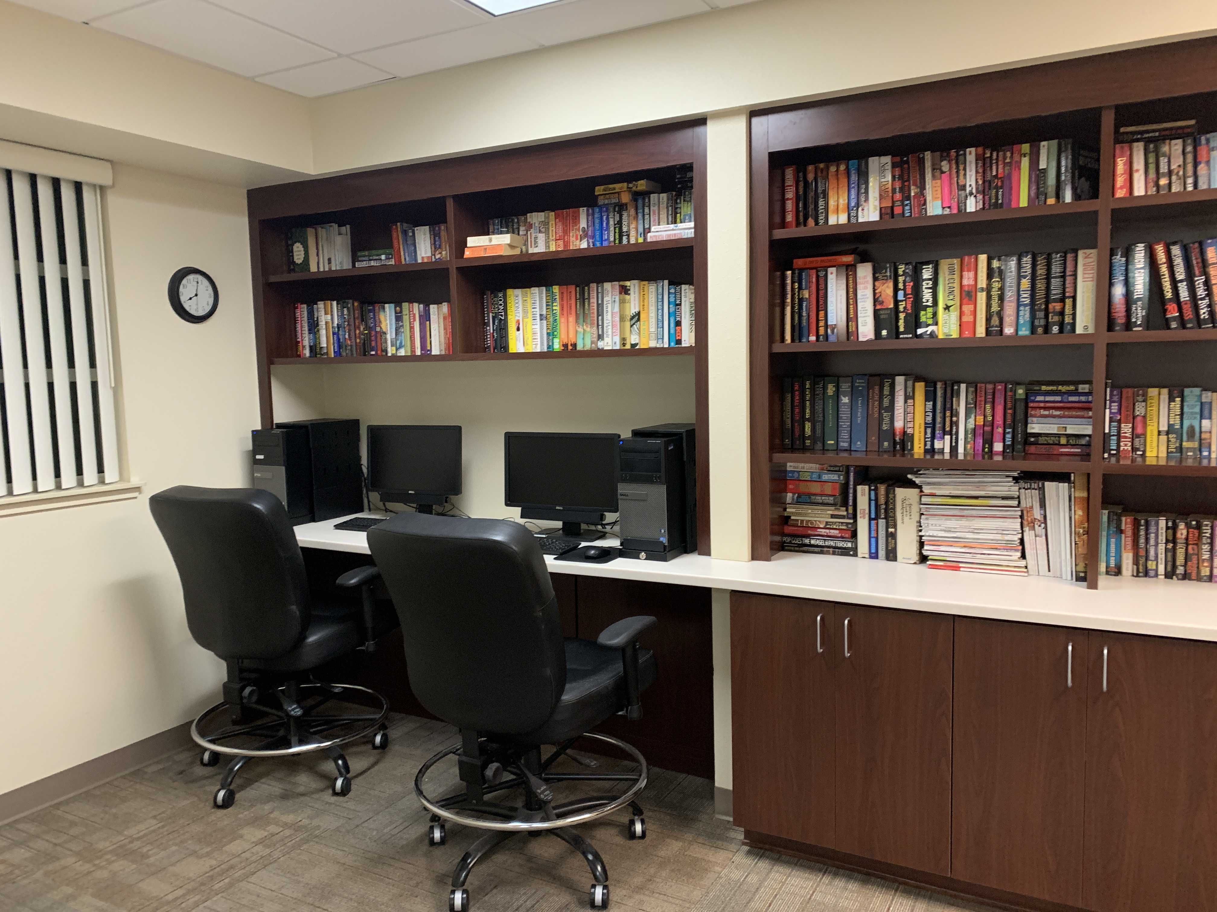 Willis Avenue computer lab. large l shaped desk with built in book shelf. Computer desktops