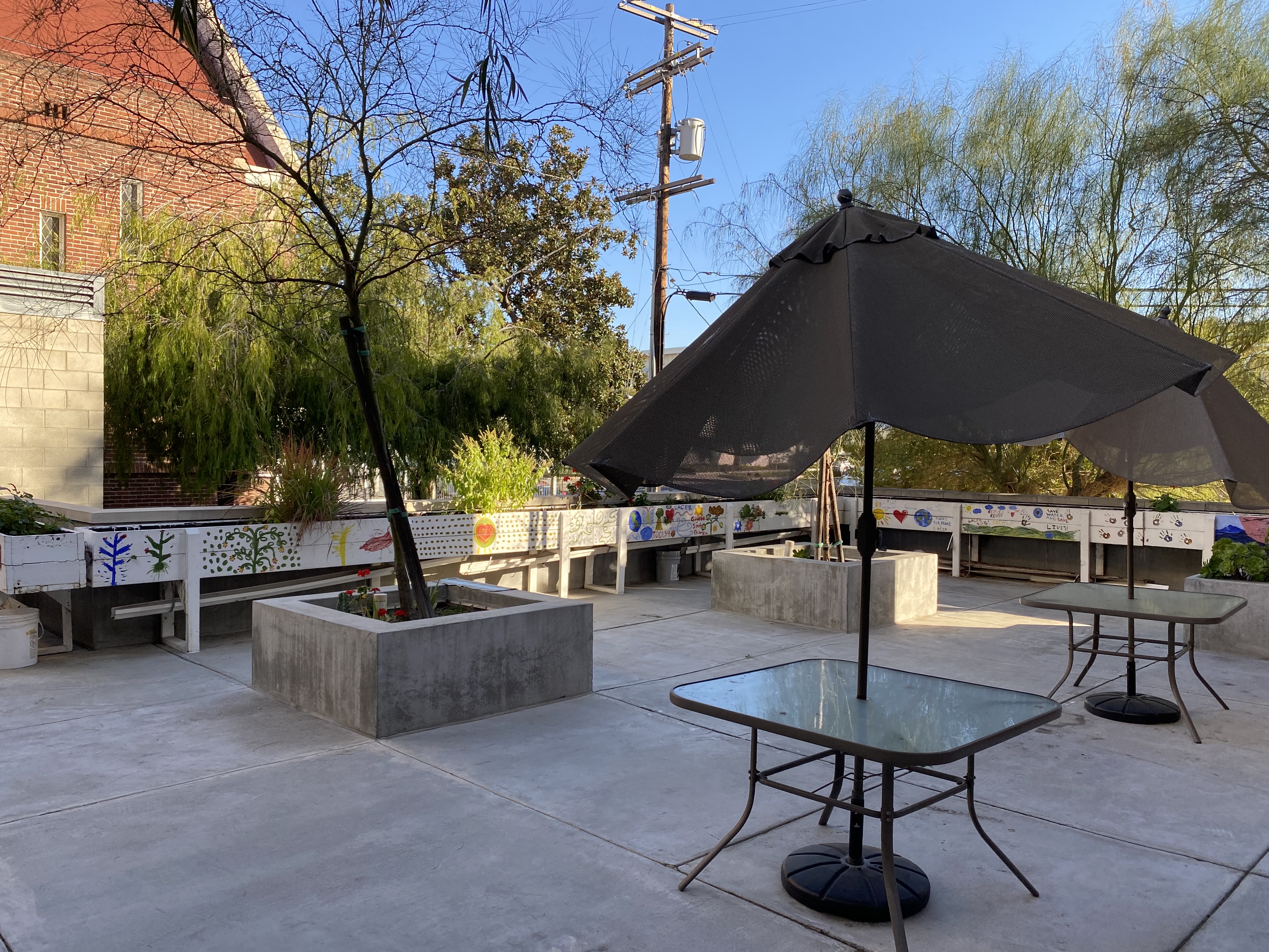 Patio with tables and umbrellas at Rosewood Gardens.