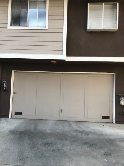 Garage door with lock on the left hand side and sprinkler above door.