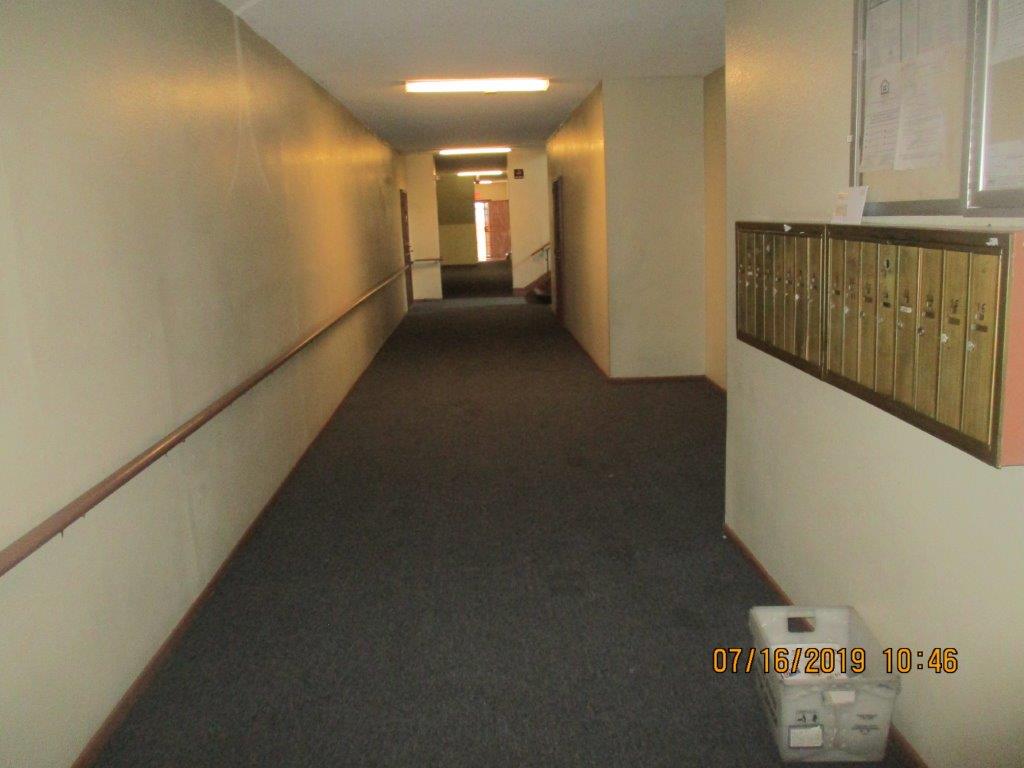 Interior view of a hallway with guardrails and mail boxes to one side