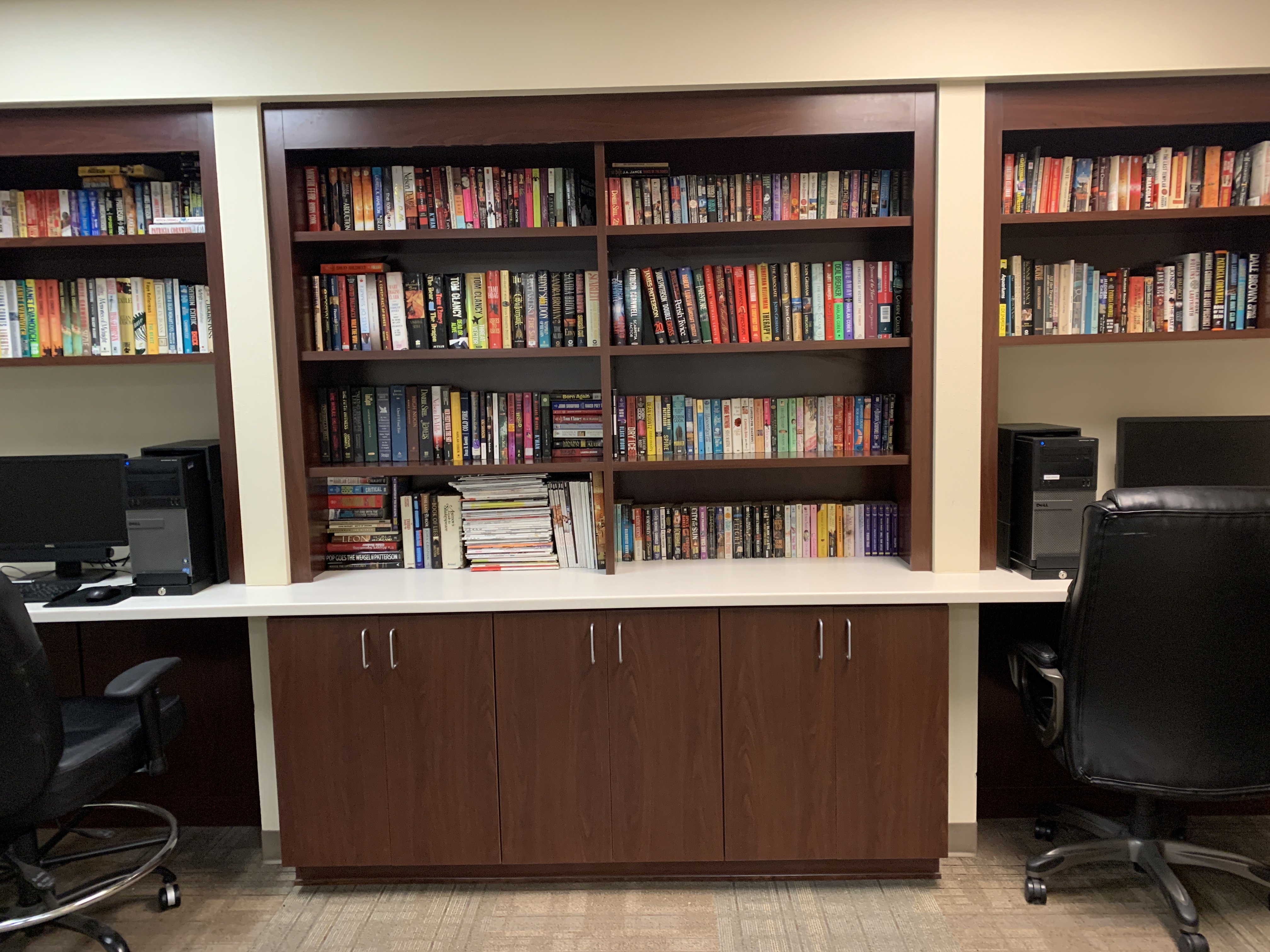 Willis Avenue library. Large book shelf along wall. built in desk with computer desktop and seating