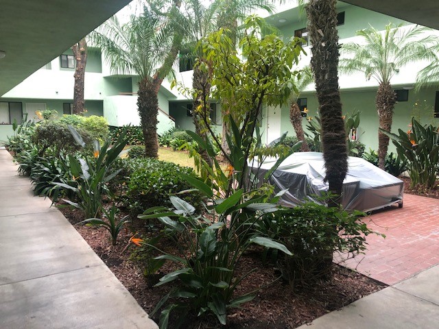 Image of the courtyard of a one story building with sectioned plants and trees