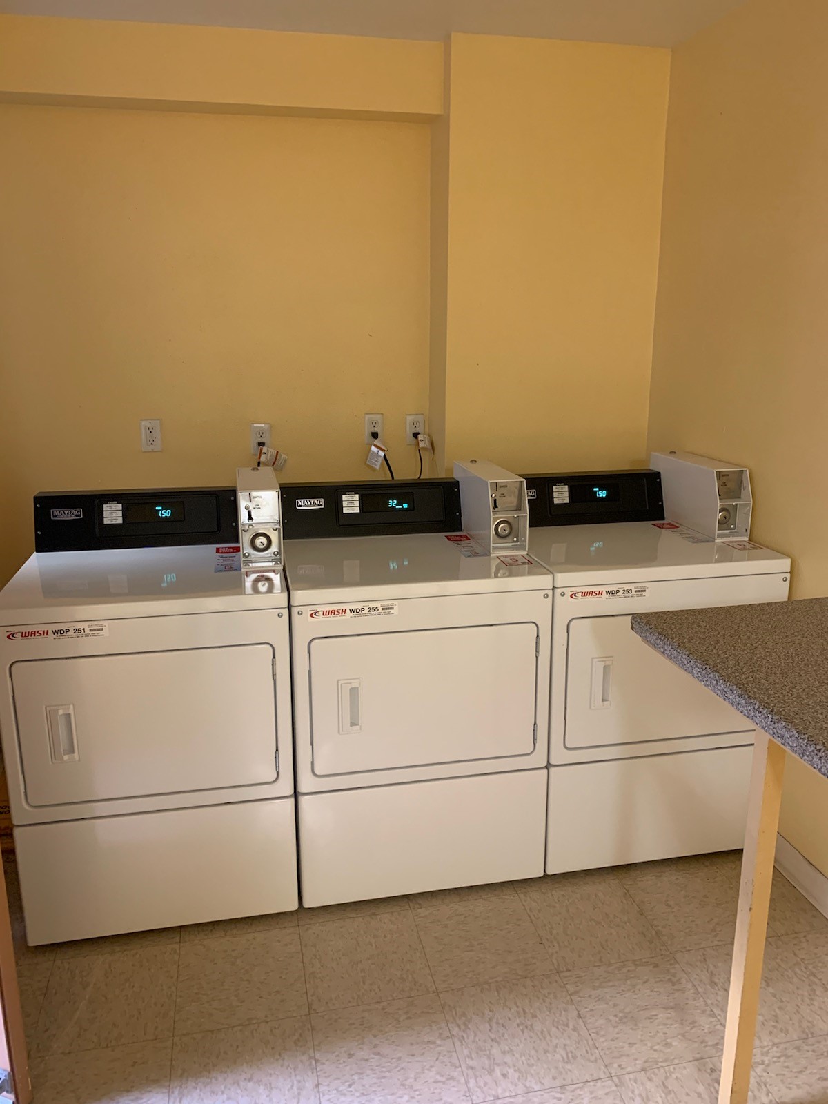 Laundry room with three machines shown and a folding table.