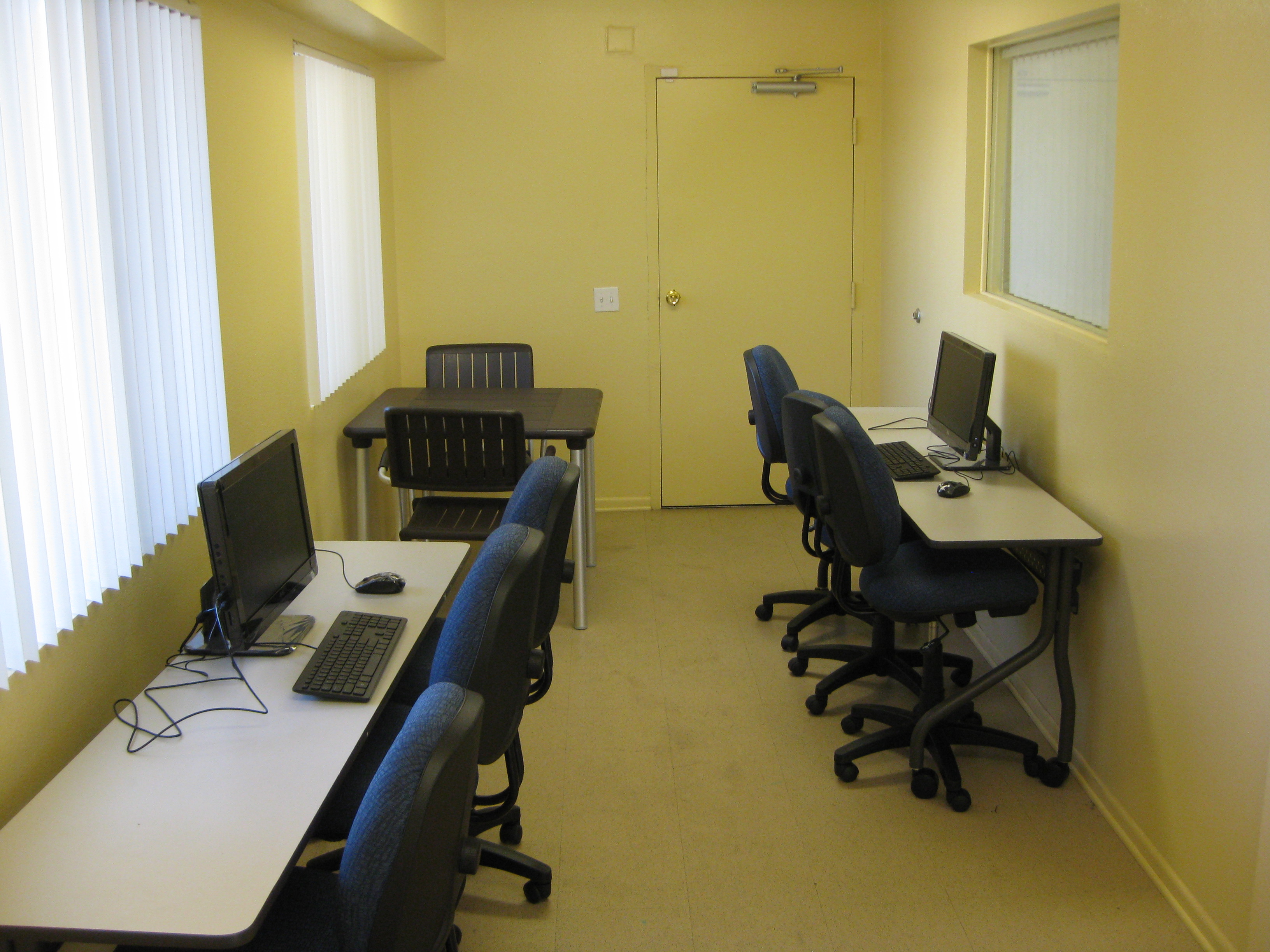 Paradise arms computer room. narrow room with two long tables with desktop computer and seating