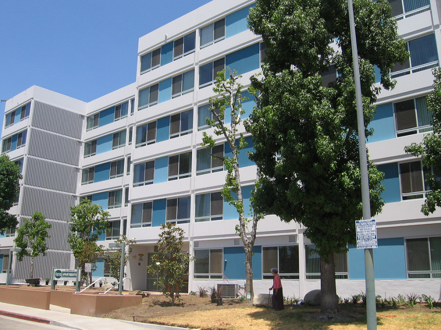 Street view of a four story building in white and blue colors. Property have disability access in the front