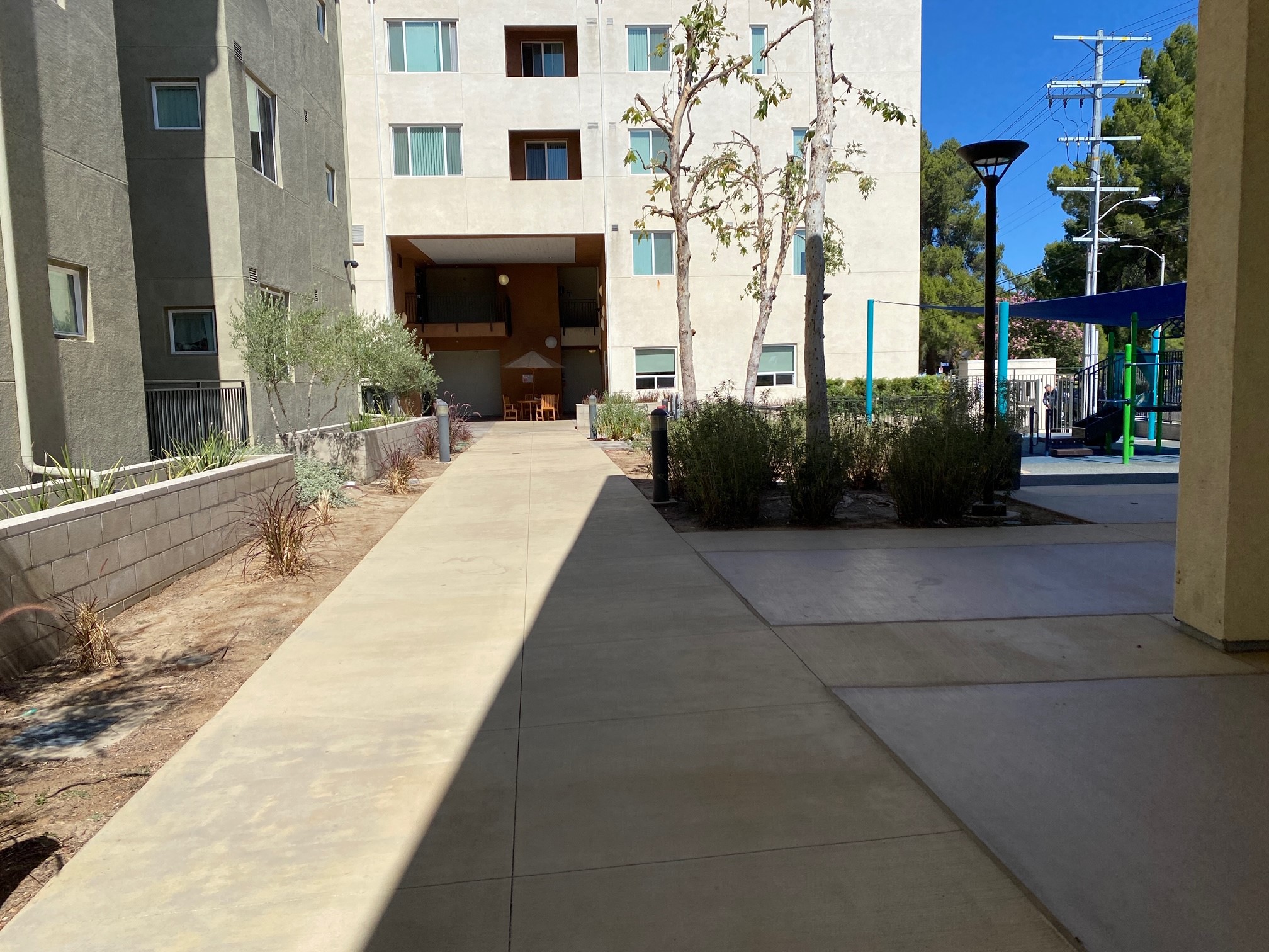 Riverwalk apartments walkway. wide walkway leading down the building and playground area.