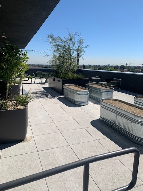 Rooftop view of common areas including raised flower beds and outdoor seating area.