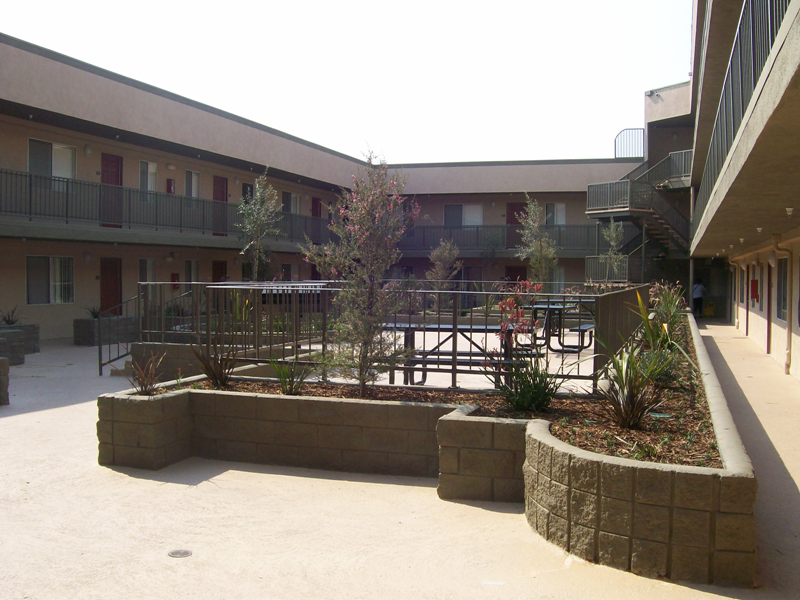 Image of 2 story building and courtyard in the center with stairs that lead to a seating area.
