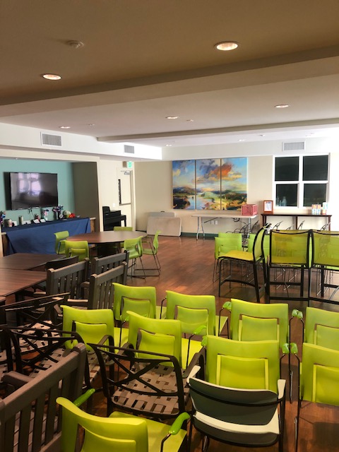 Image of the community room with green and brown chairs