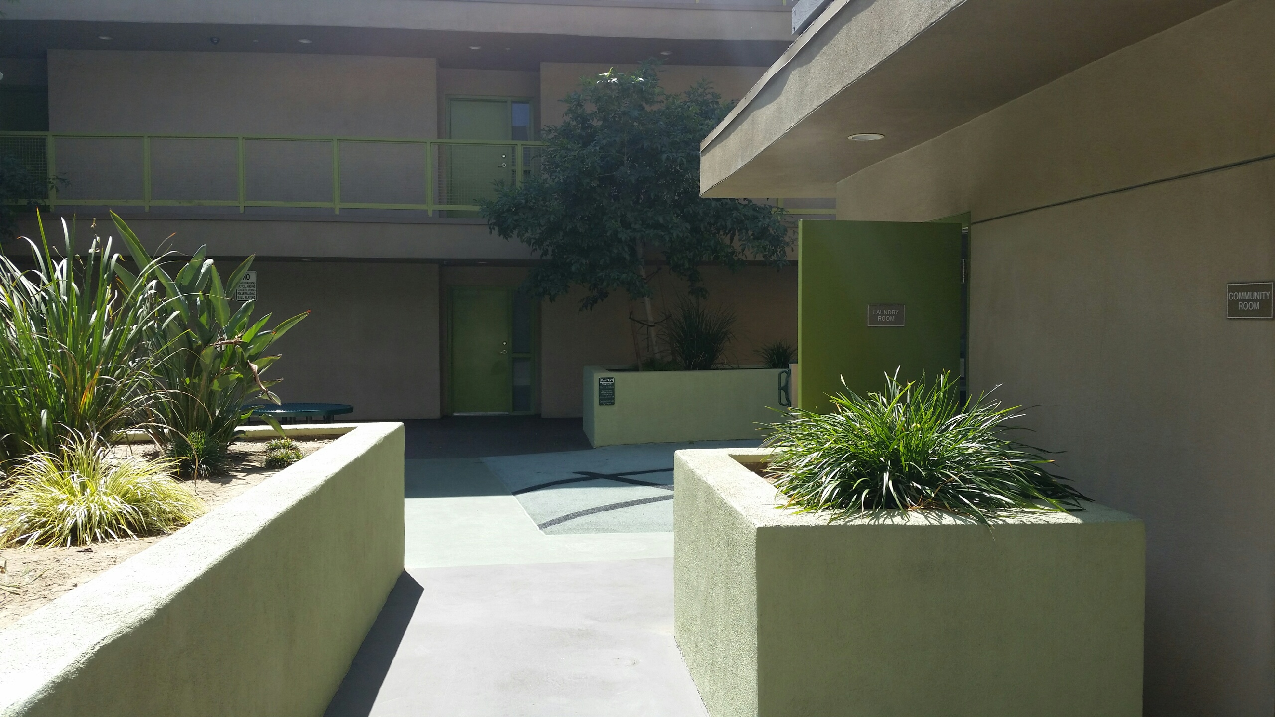 Sichel family housing courtyard area. Large area with with planters throughout. bench and table seating area