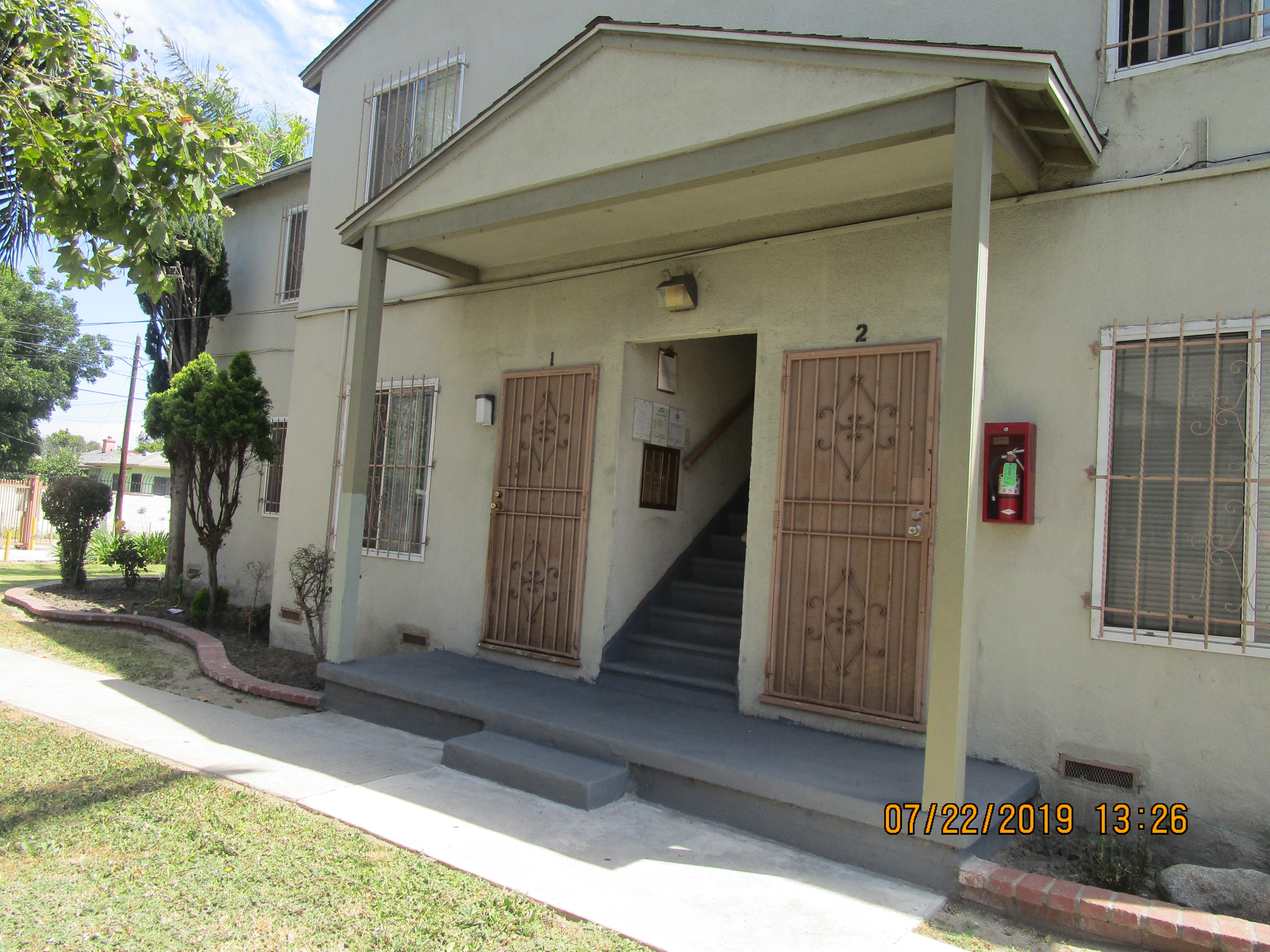 Close up view of the front entrance to the property with doors to ground level units and stairs leading to the upper level