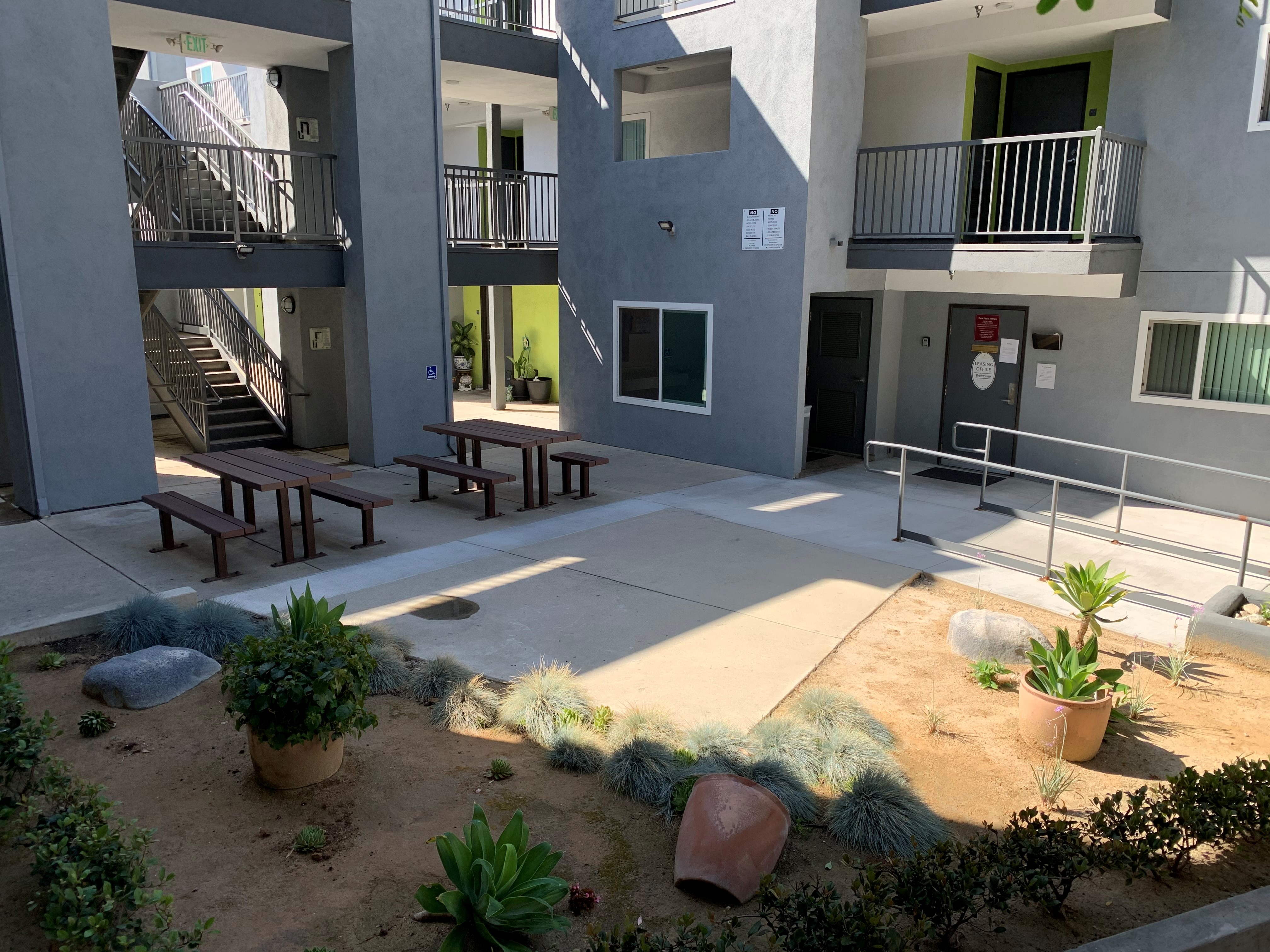 New Park Place courtyard area. accessibility ramp leading into area. Picnic table seating. Desert garden landscaping