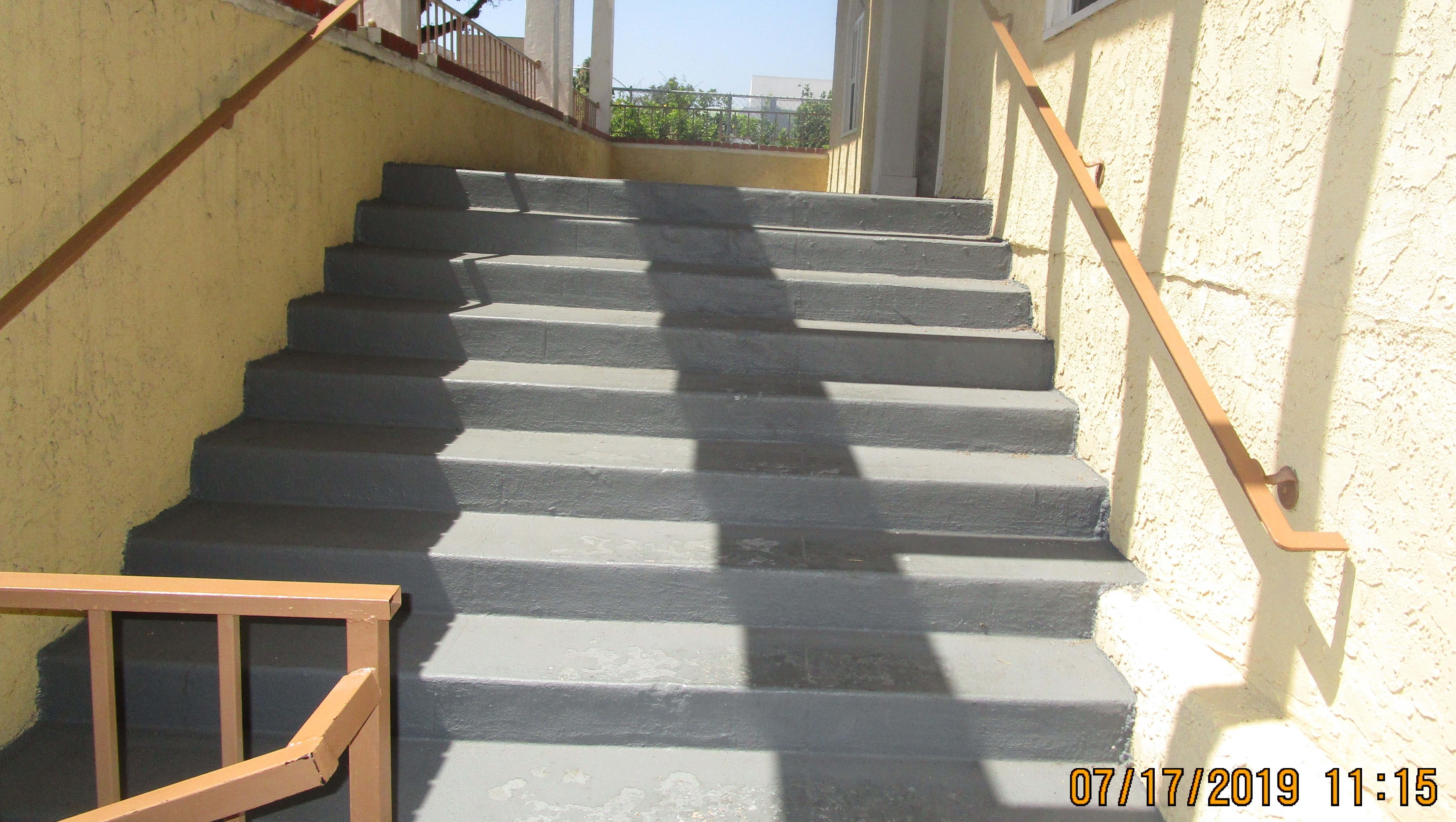 View of gray concrete stairway, handrails on each side.