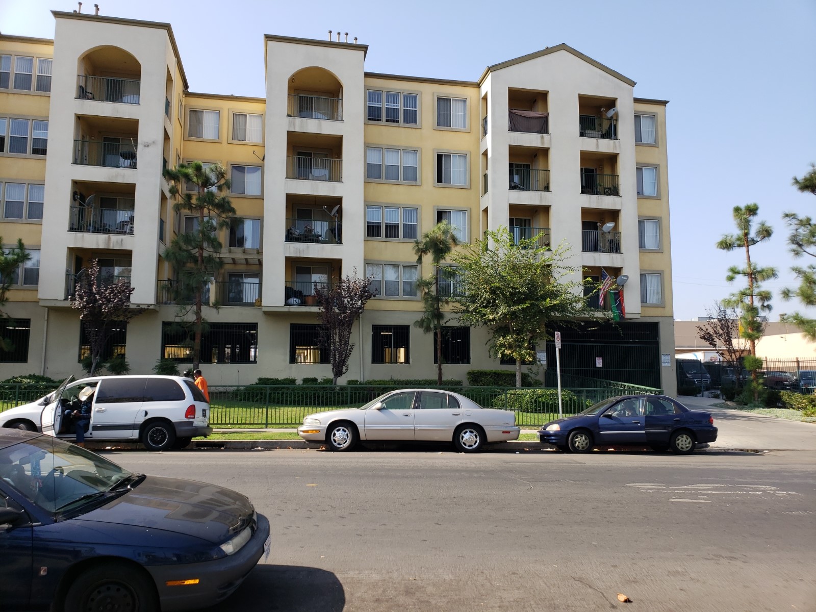 Street view of Harvard Yard. Five story building with gated tenant parking garage on ground floor. Select units with balcony access