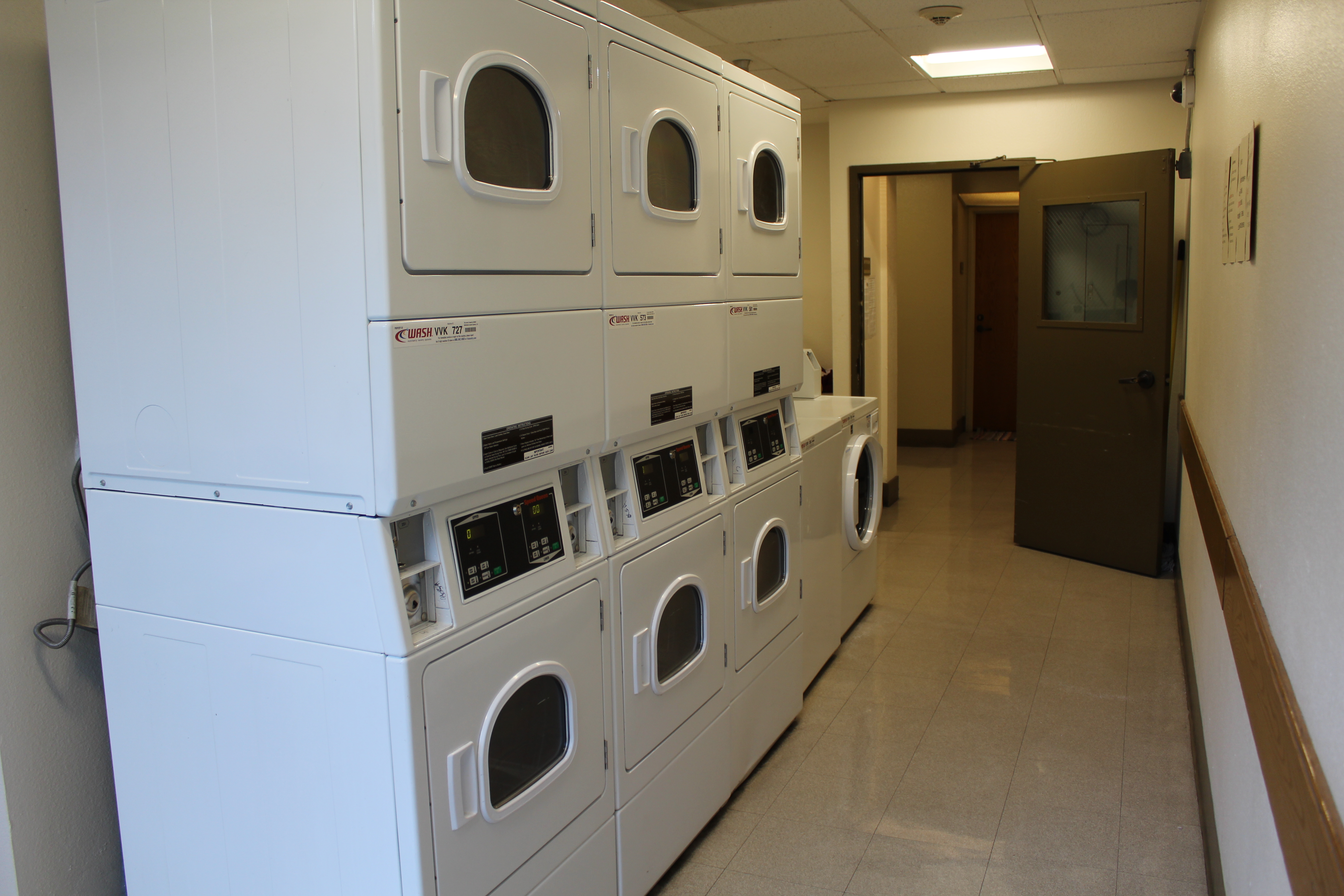 Interior view of a laundry room in Angelus Plaza 2 showing 7 white machines.