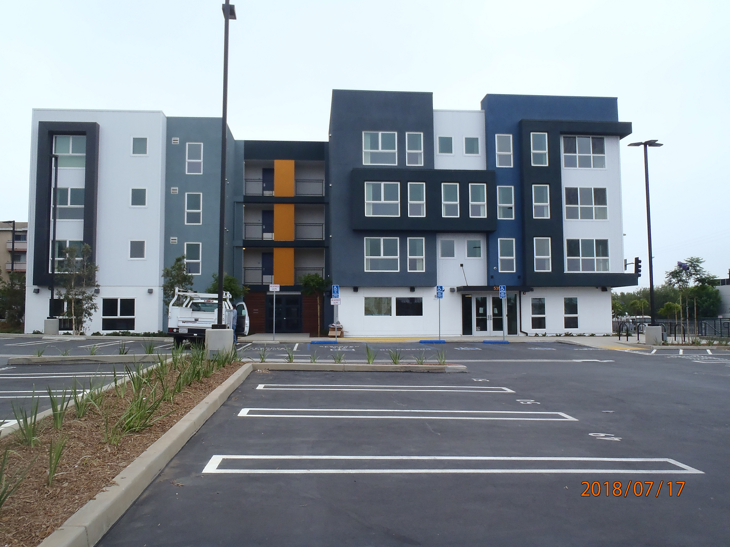 Front view of 4 floor building with parking lot
