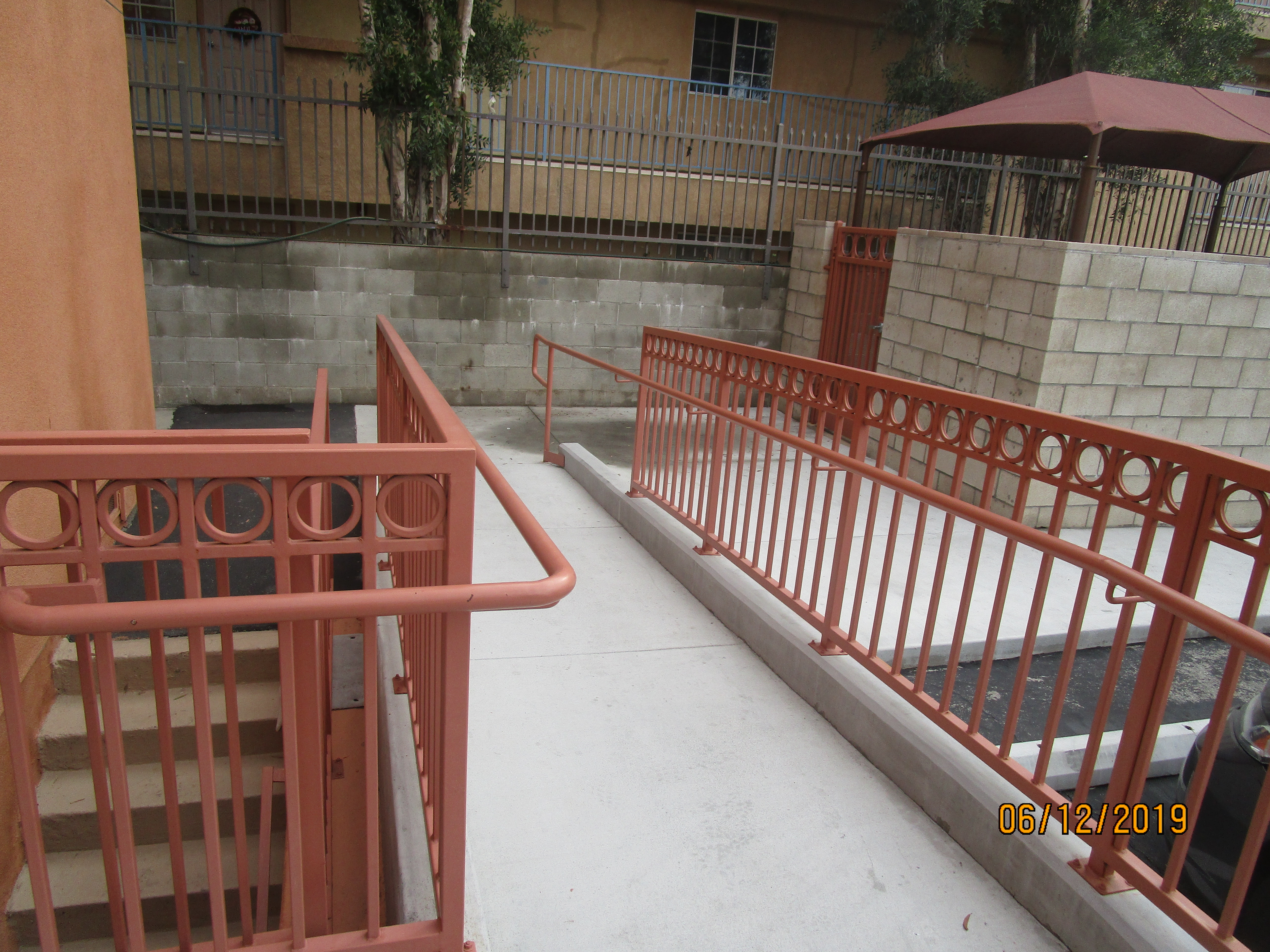 Side view of a concrete ramp going toward the building parking, handrails.