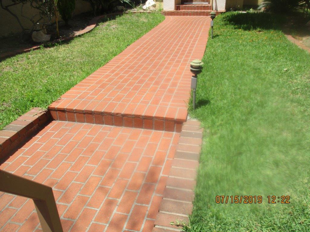 Image of a brick walkway with grass on both sides