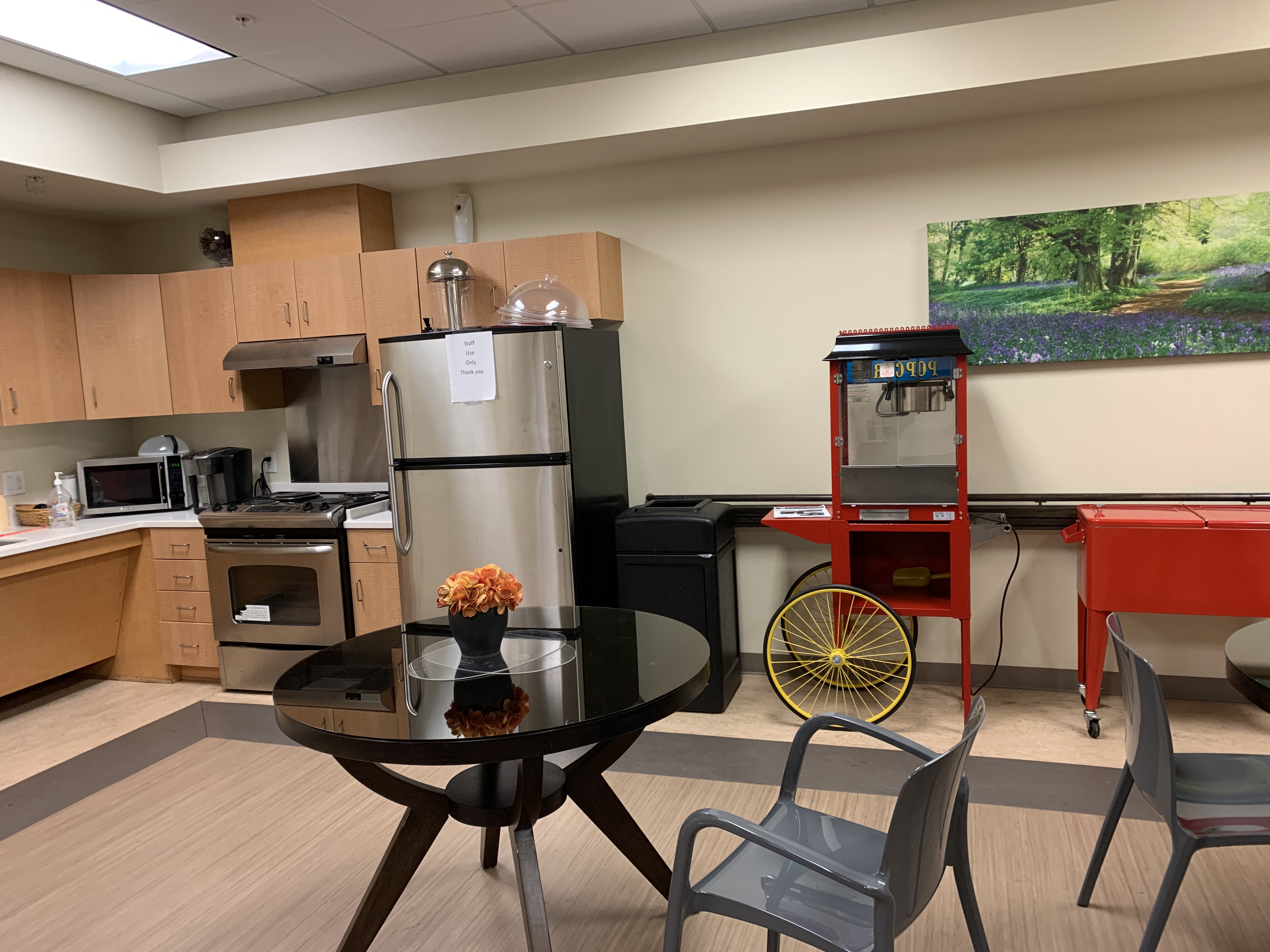 Willis Avenue community room. Room has full kitchen access, popcorn maker, cooler, and table and chairs