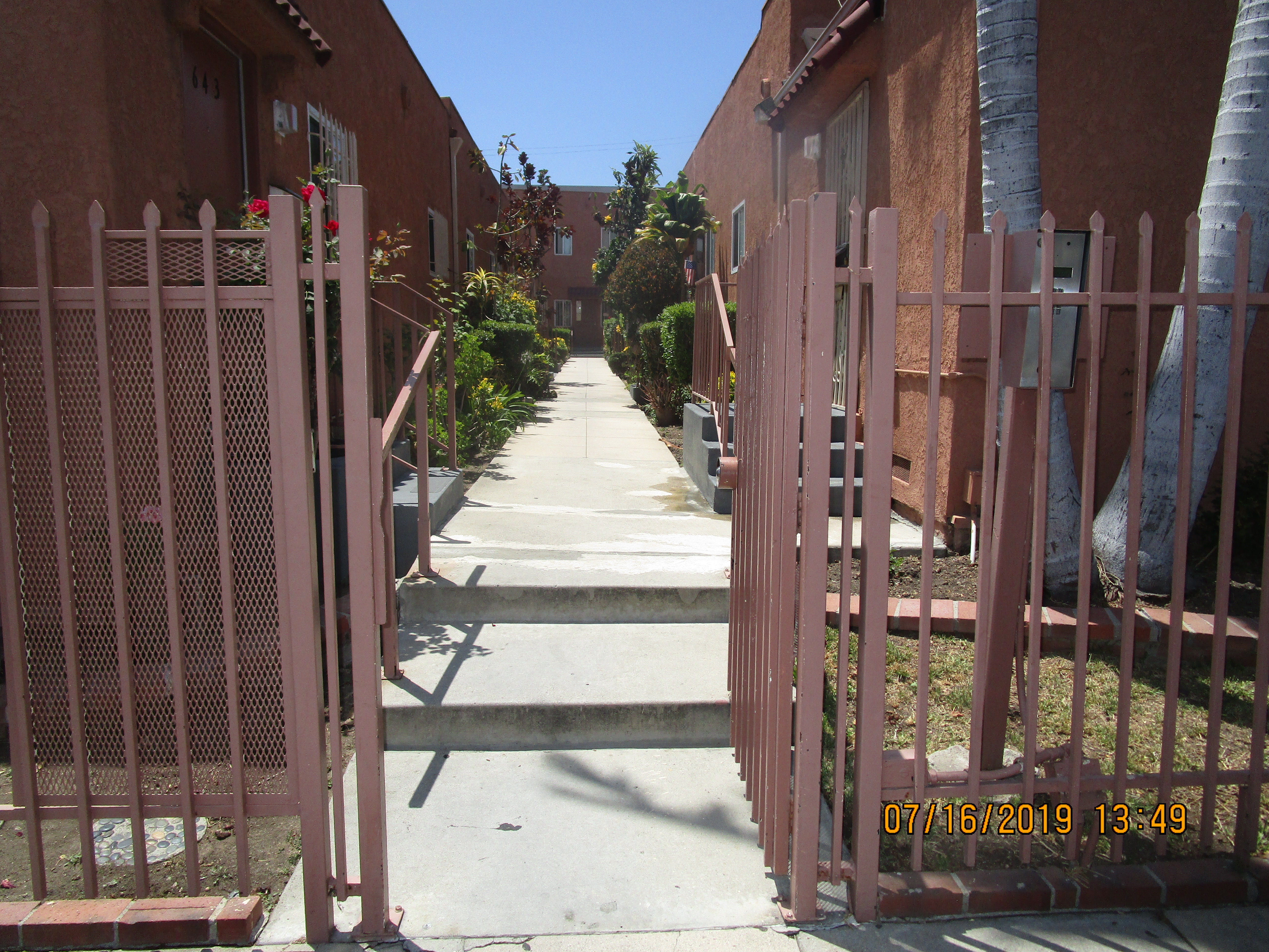 Close up view of a gated entrance to the building showing the pathway in between the units
