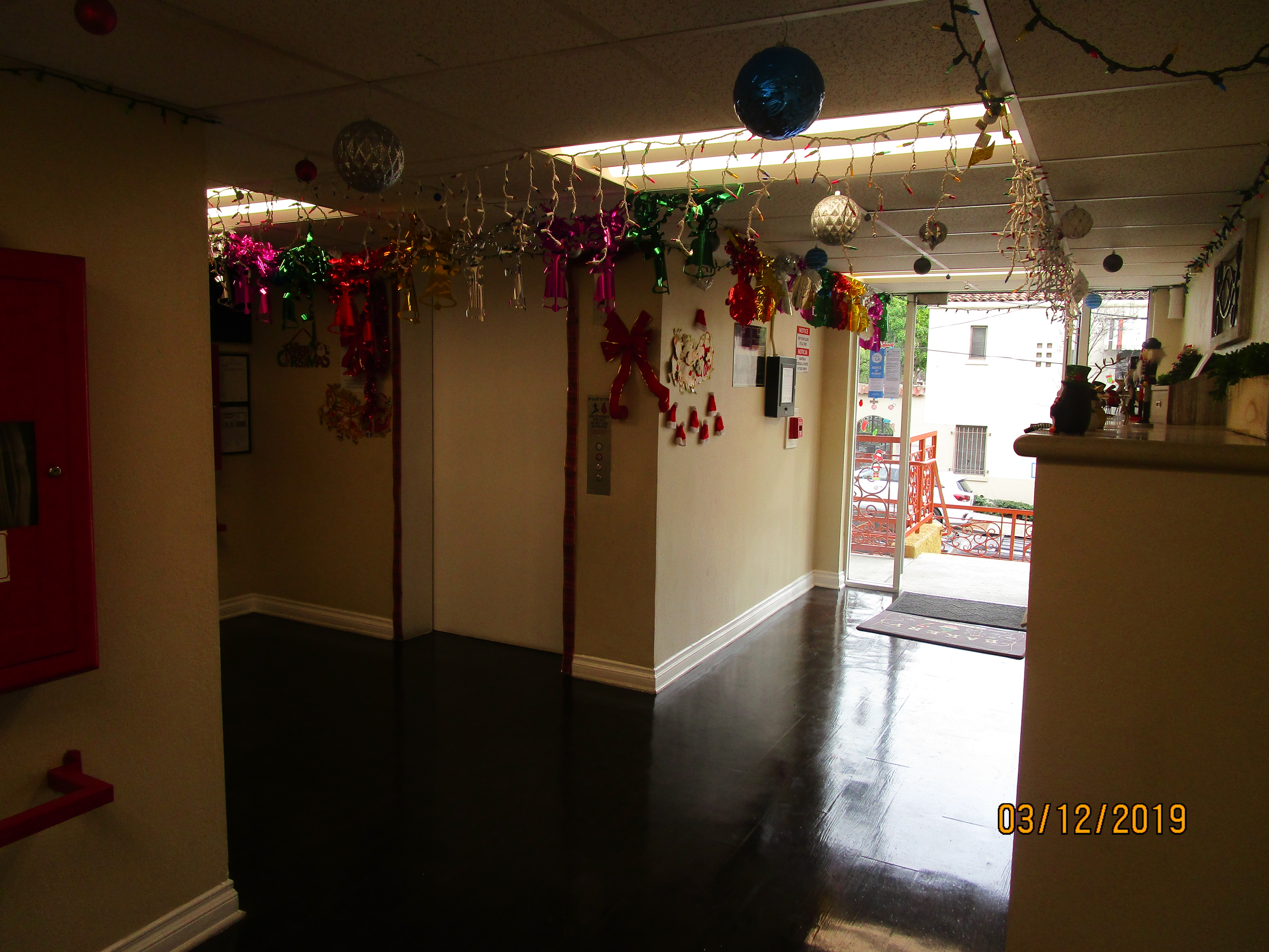 View of a room full of decorations hanging from the ceiling, entrance/Exit carpet in front of the door.