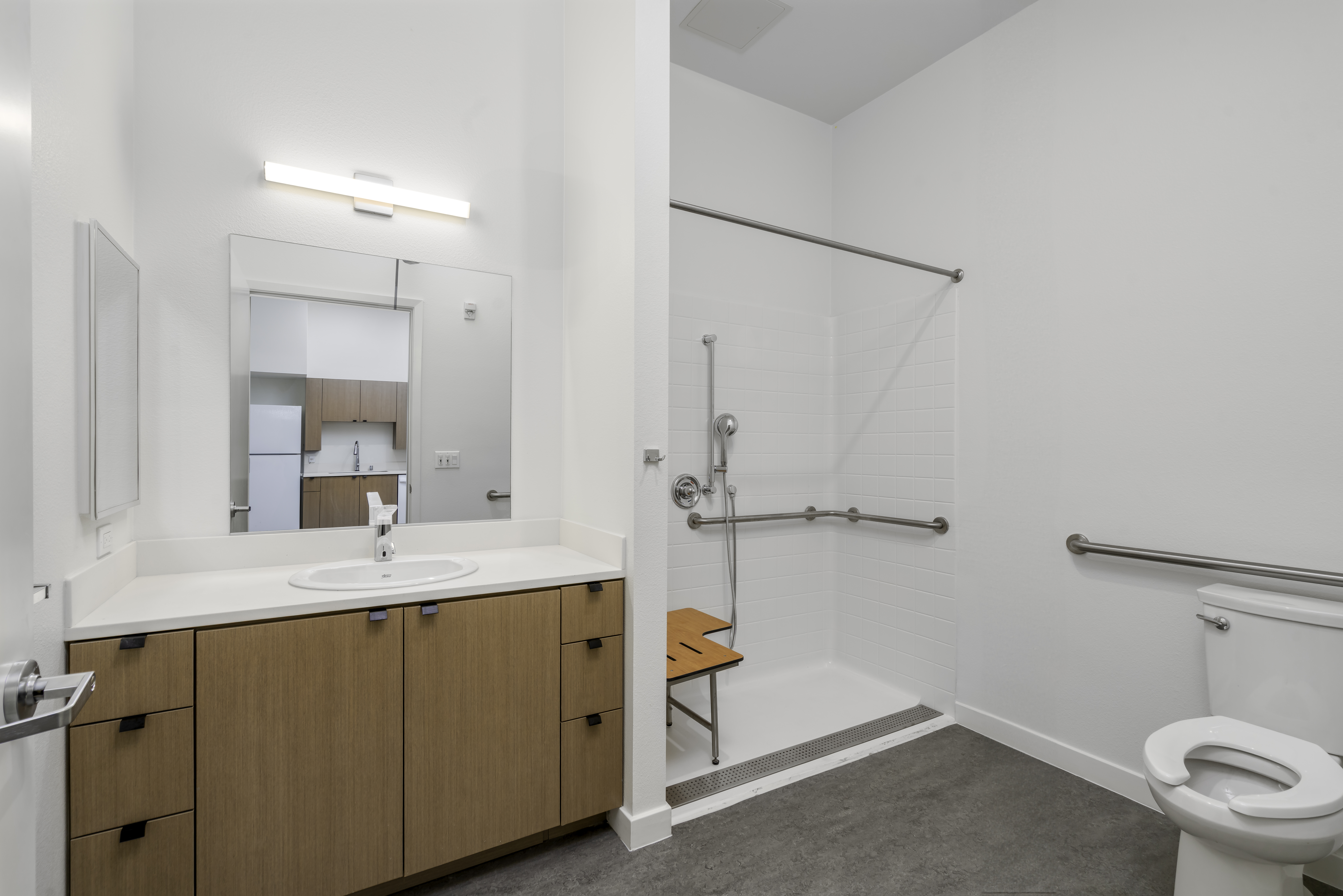 Unit - Bathroom. Walk in shower wit grab bars and adjustable showerhead. Includes shower bench.