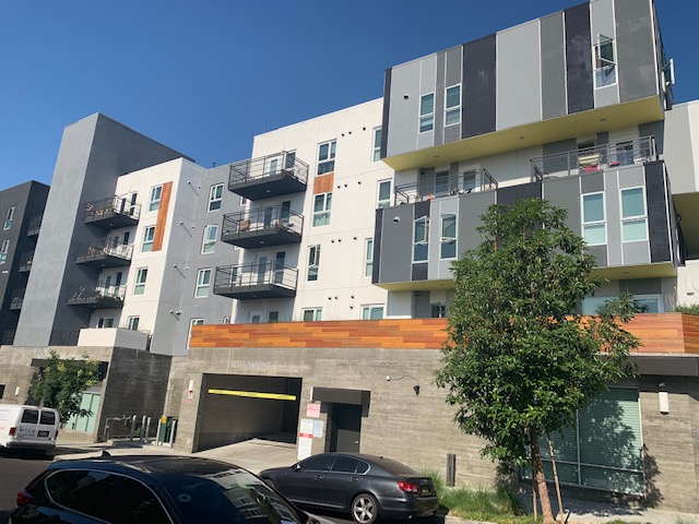 Street view of 5400 Hollywood Family Apartments. Multi-level building with underground parking entrance in front of building
