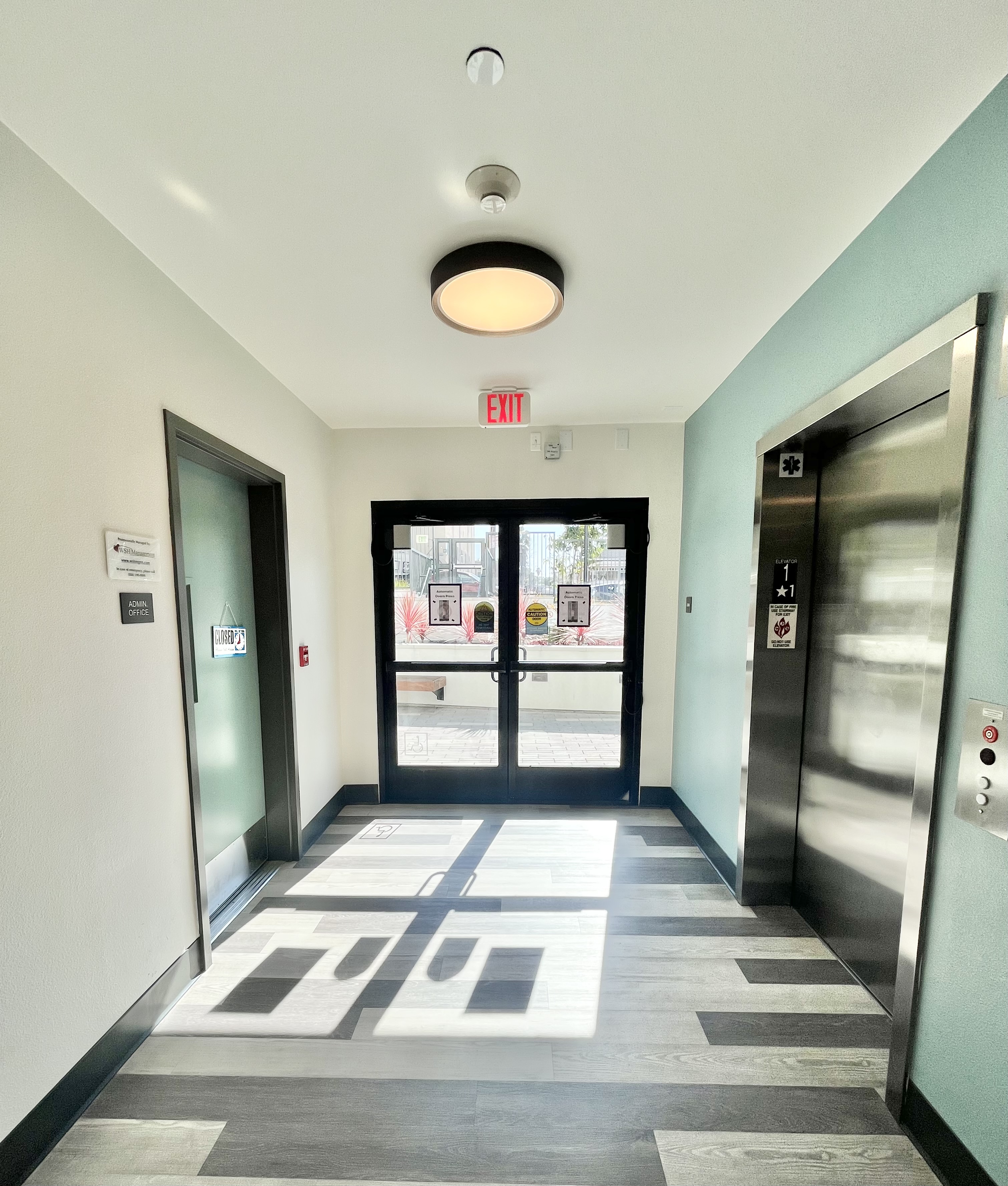 The lobby entry door is situated on the first floor. Upon entering, you will find office doors to one side and the elevator to the other.