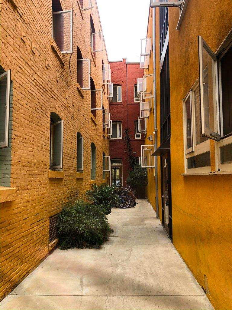 Exterior view of a pathway between buildings at Amistad Apartments.