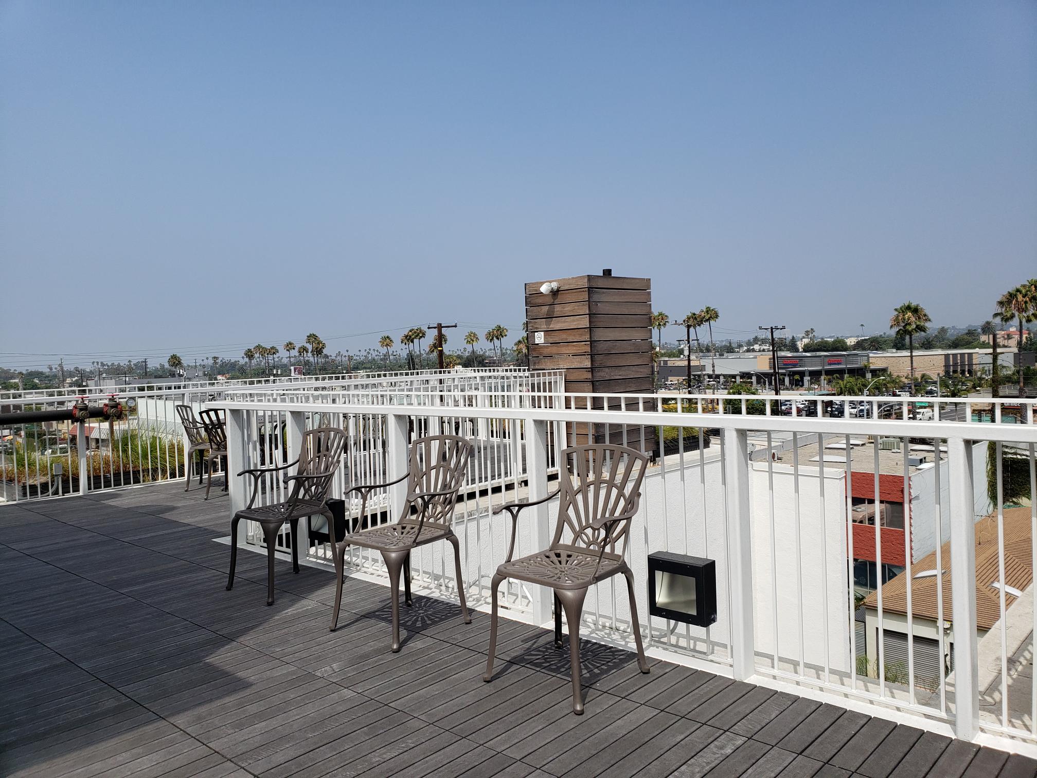 View of building rooftop terrace equipped with tables and chairs